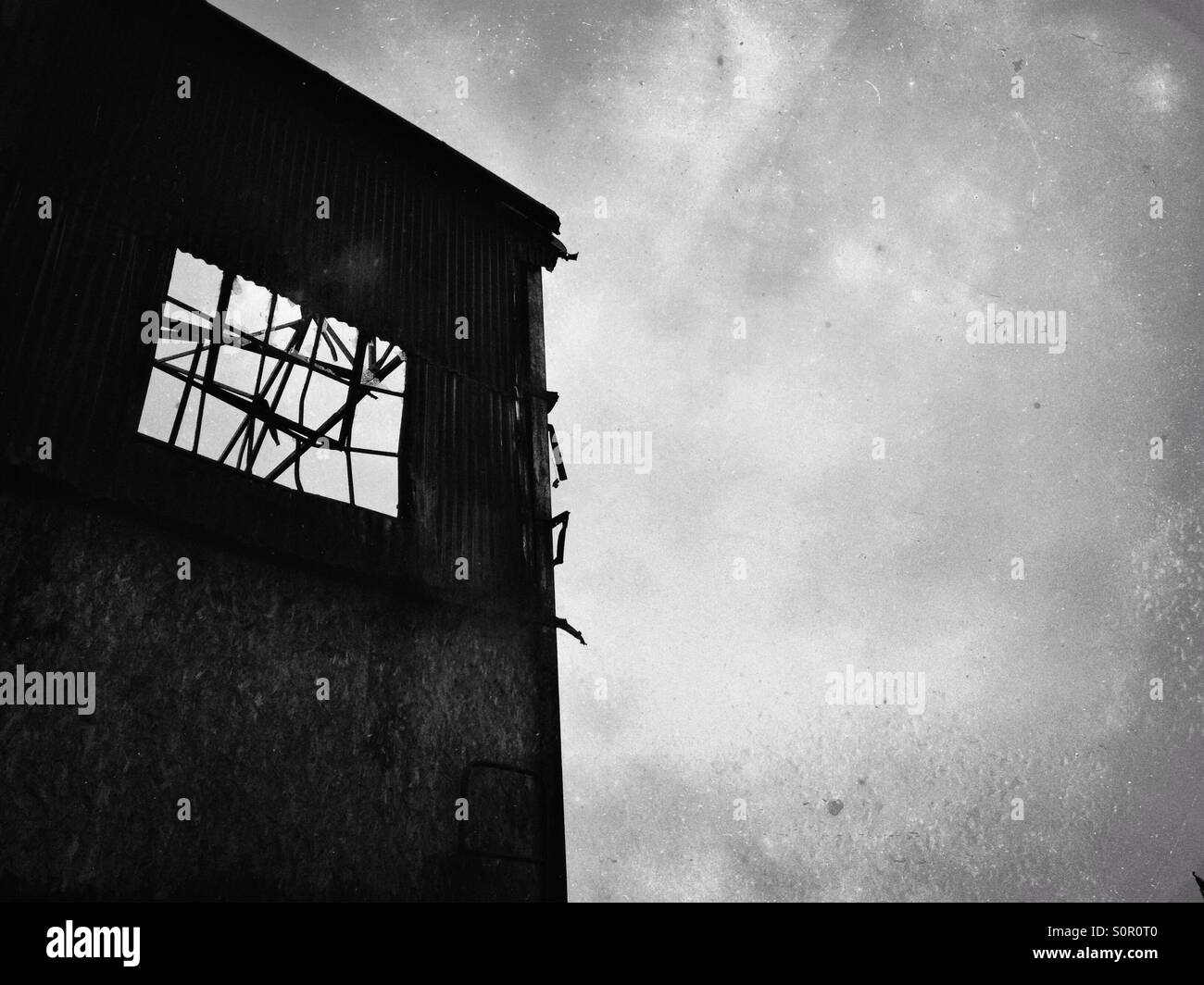 Silhouette zerbrochenes Fenster in verlassenen Fabrik - Smartphone-aufgenommenes Stockfoto