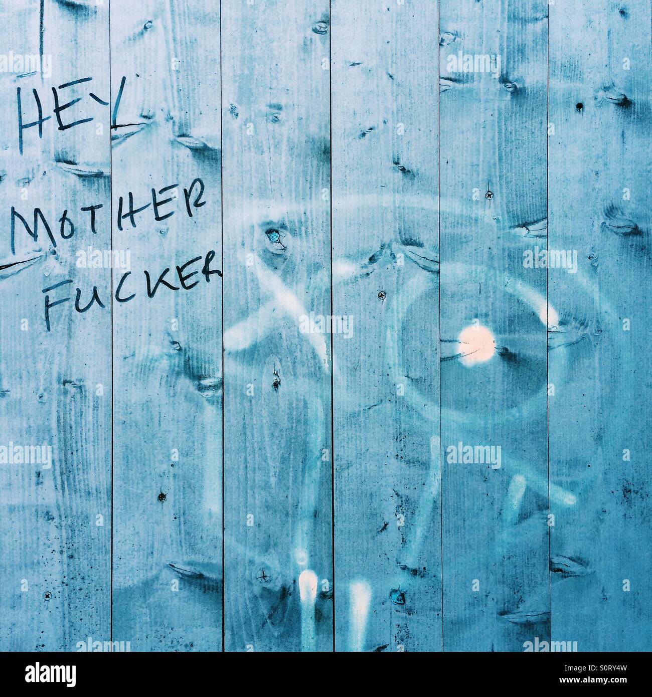 Bunte Sprache Graffiti auf blauen Zaun Stockfoto