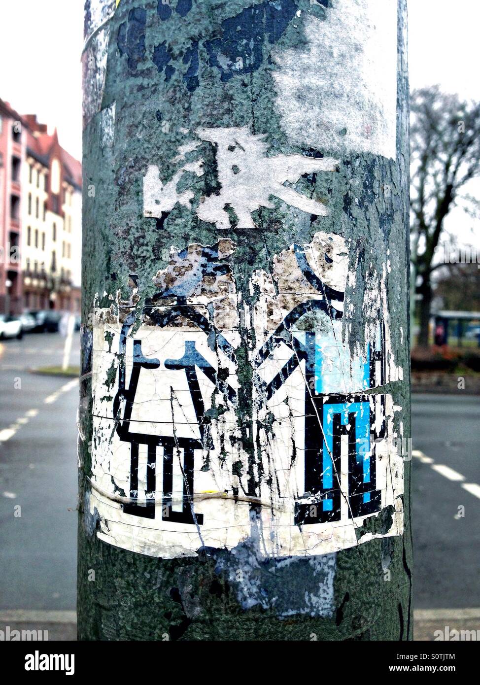 Eine Straße Kunst Aufkleber eines Mannes und einer Frau, die Hand in Hand auf den Pol einer Verkehrsampel in Berlin, Deutschland - Smartphone-aufgenommenes Stockfoto