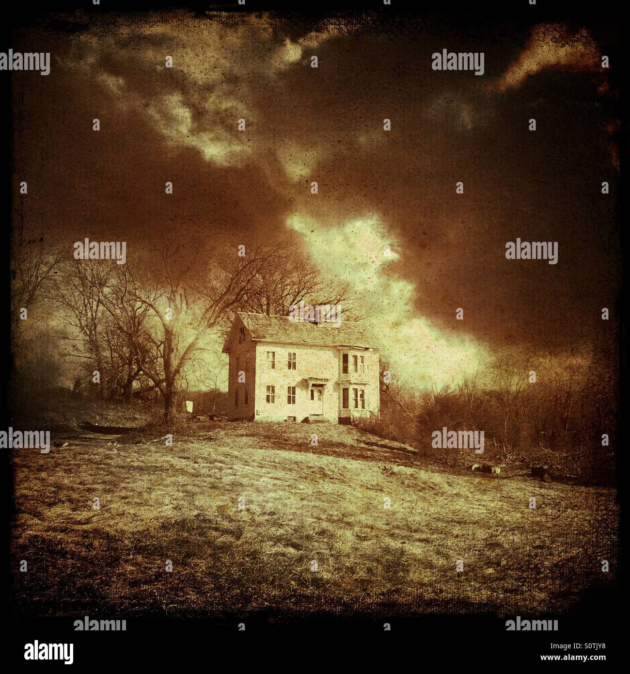 Verlassenes Haus auf einem Hügel mit düsteren Himmel Stockfoto