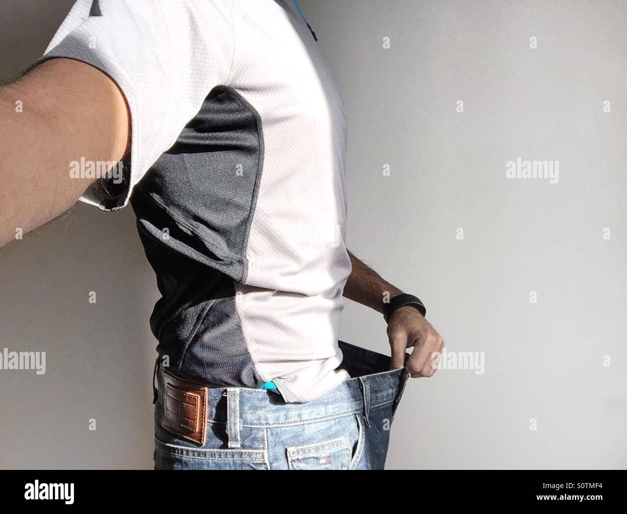 Gewicht-Verlust - ein Mann trug seine alte jeans Stockfoto