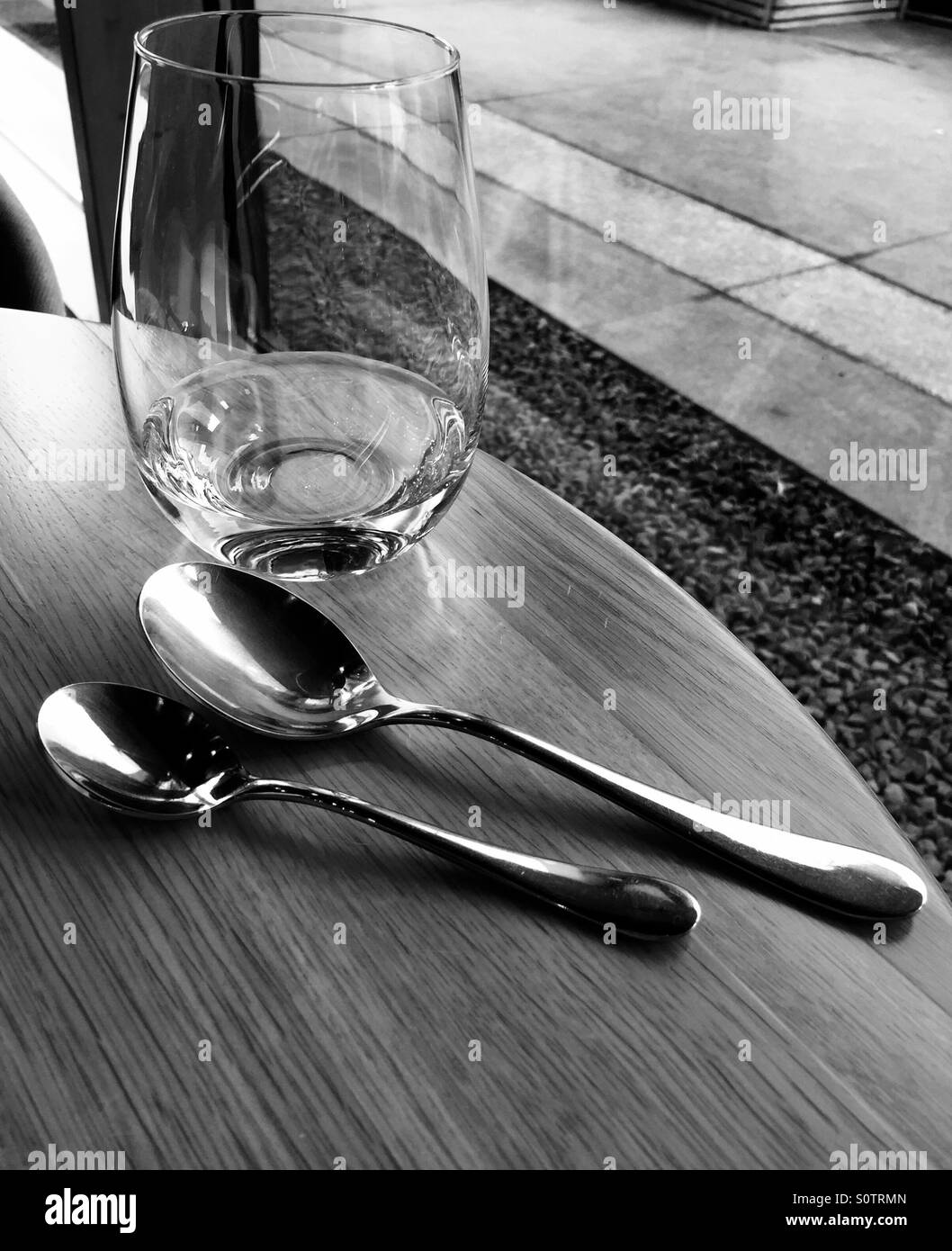 Ein leeres Glas auf dem Tisch mit Löffel Stockfoto
