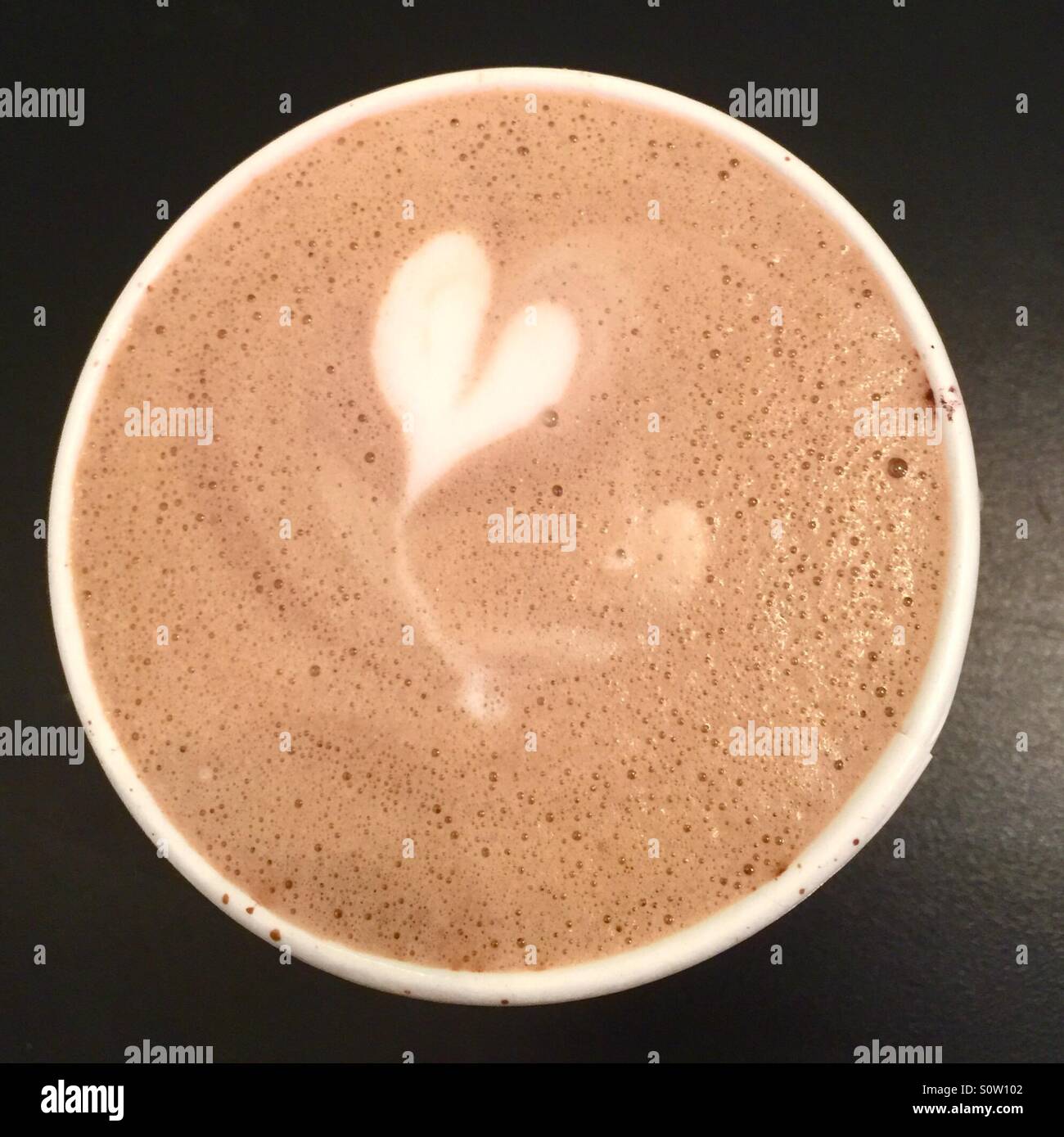 Eine Tasse Latte/Kaffee mit Herz oben drauf. Stockfoto