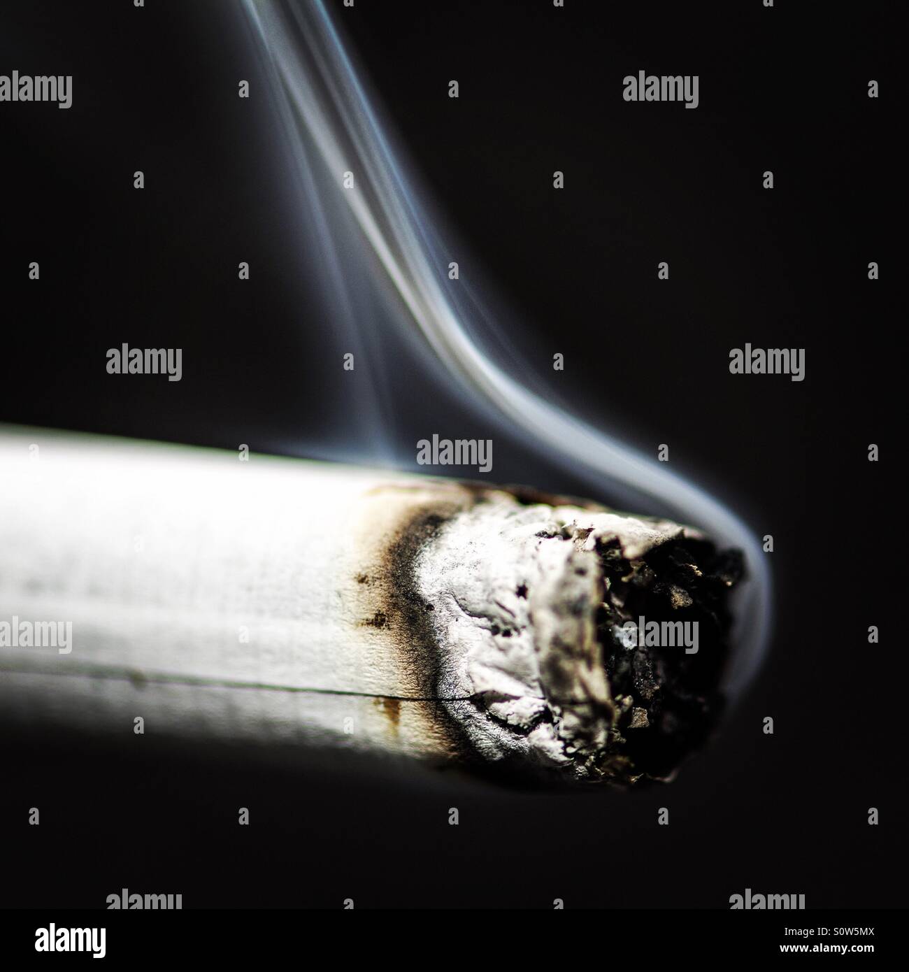 Zigarette auf einem schwarzen Hintergrund - Smartphone-aufgenommenes Stockfoto