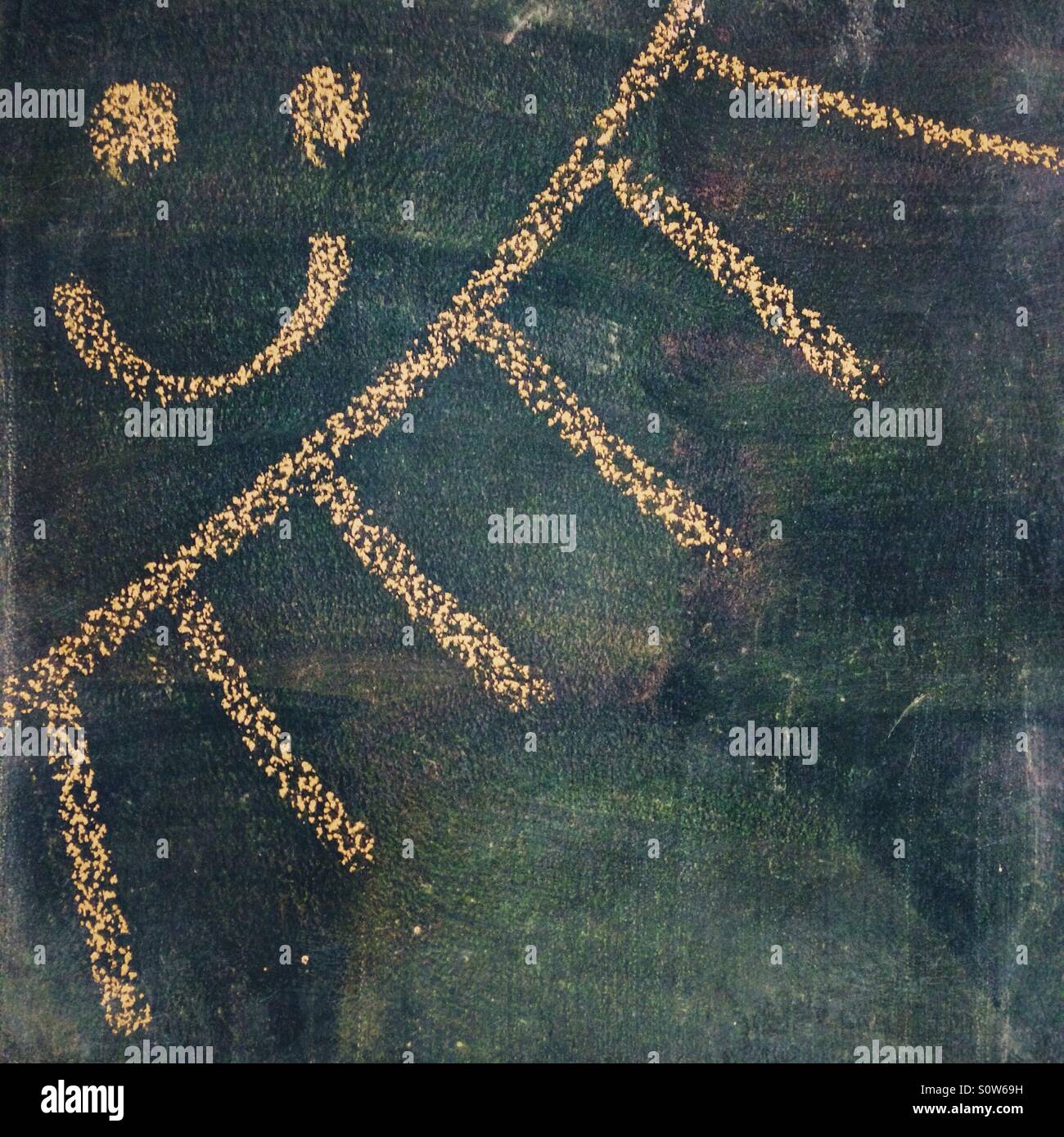 Eine glückliche lachende Sonne auf eine schwarze Tafel Stockfoto