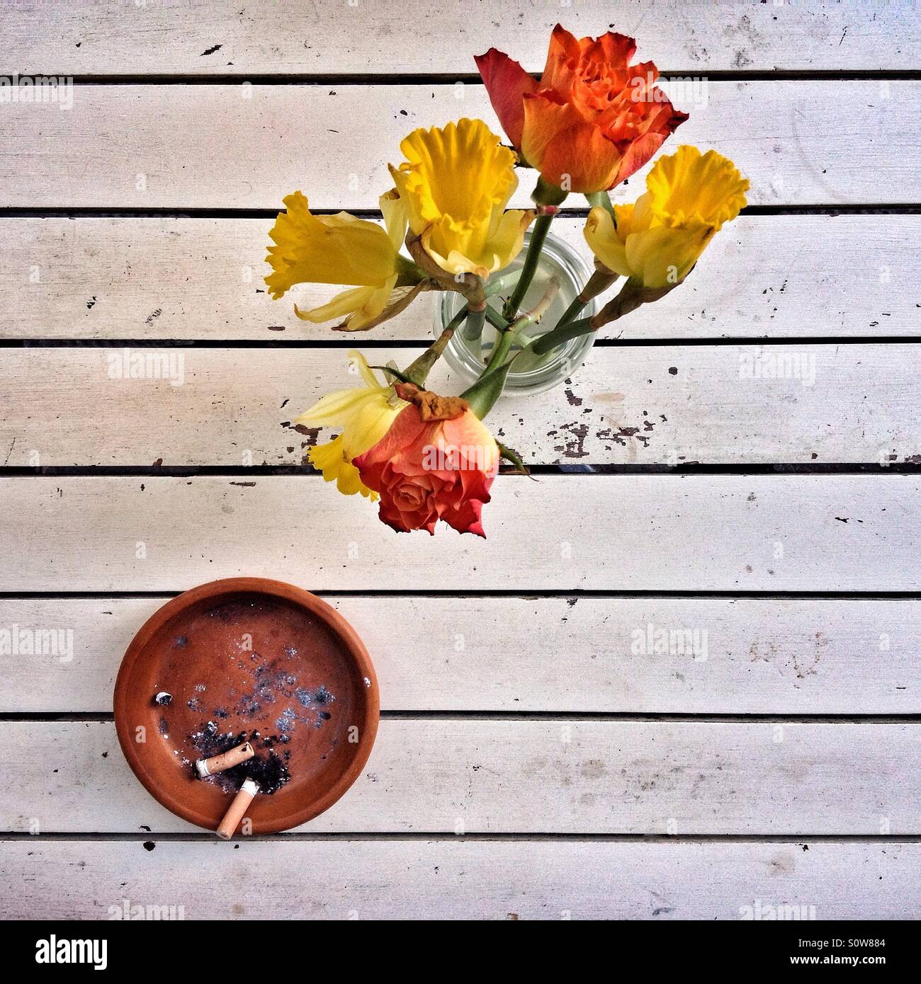 Eine Vase mit Blumen und einen Aschenbecher auf dem Tisch vor einem Café in einer Stadt in England Stockfoto