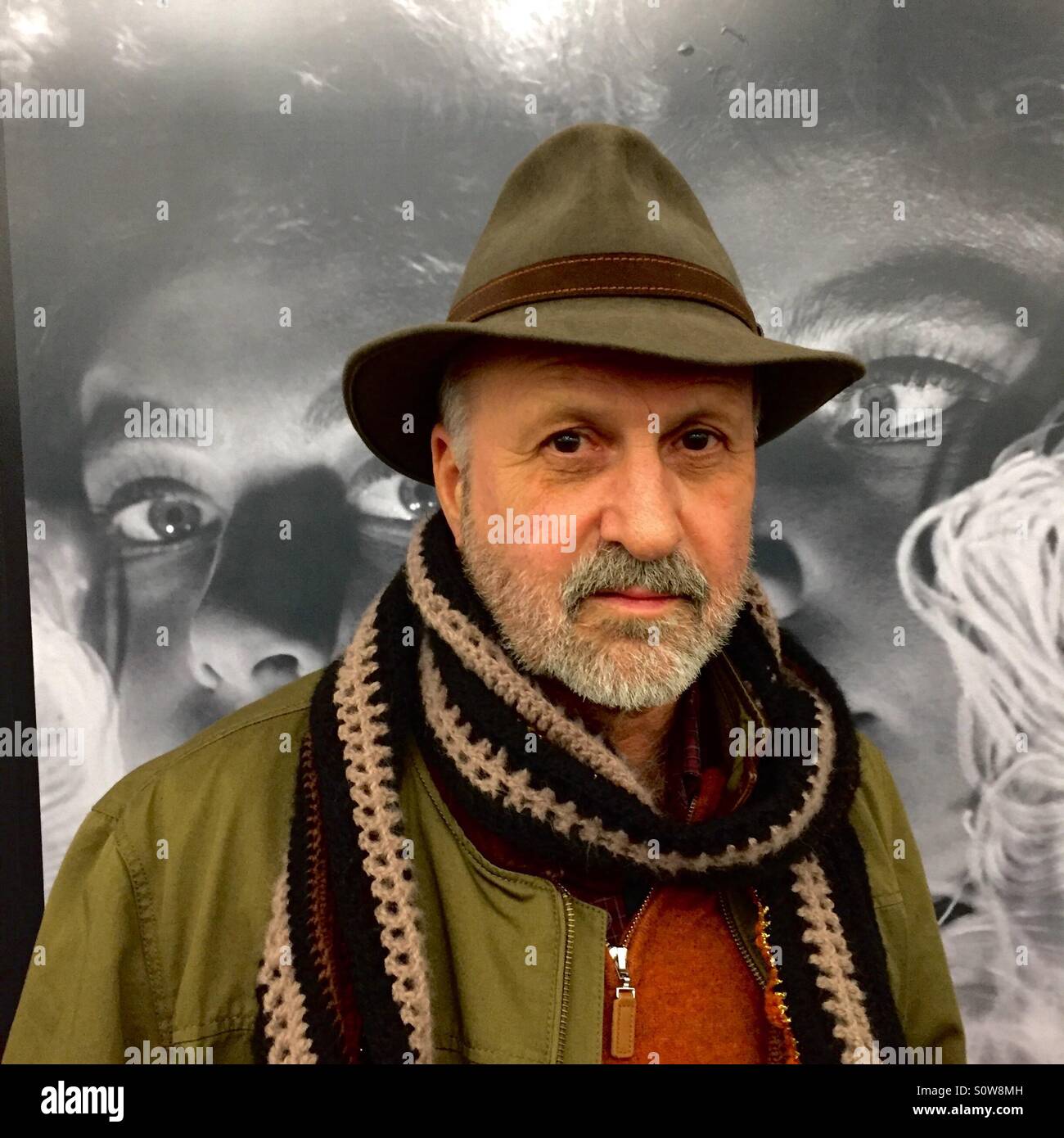 Bärtiger Mann in Schal und Mütze von Augen hinter ihm beobachtet Stockfoto