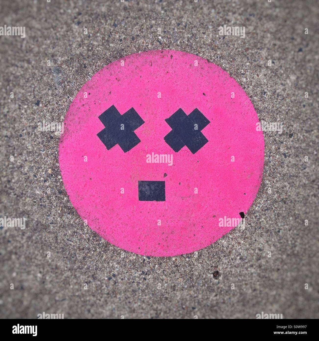 Schwindel oder erstaunt Gesicht Smiley Emoticon oder Emoji erstellt auf dem Bürgersteig mit Klebeband Stockfoto