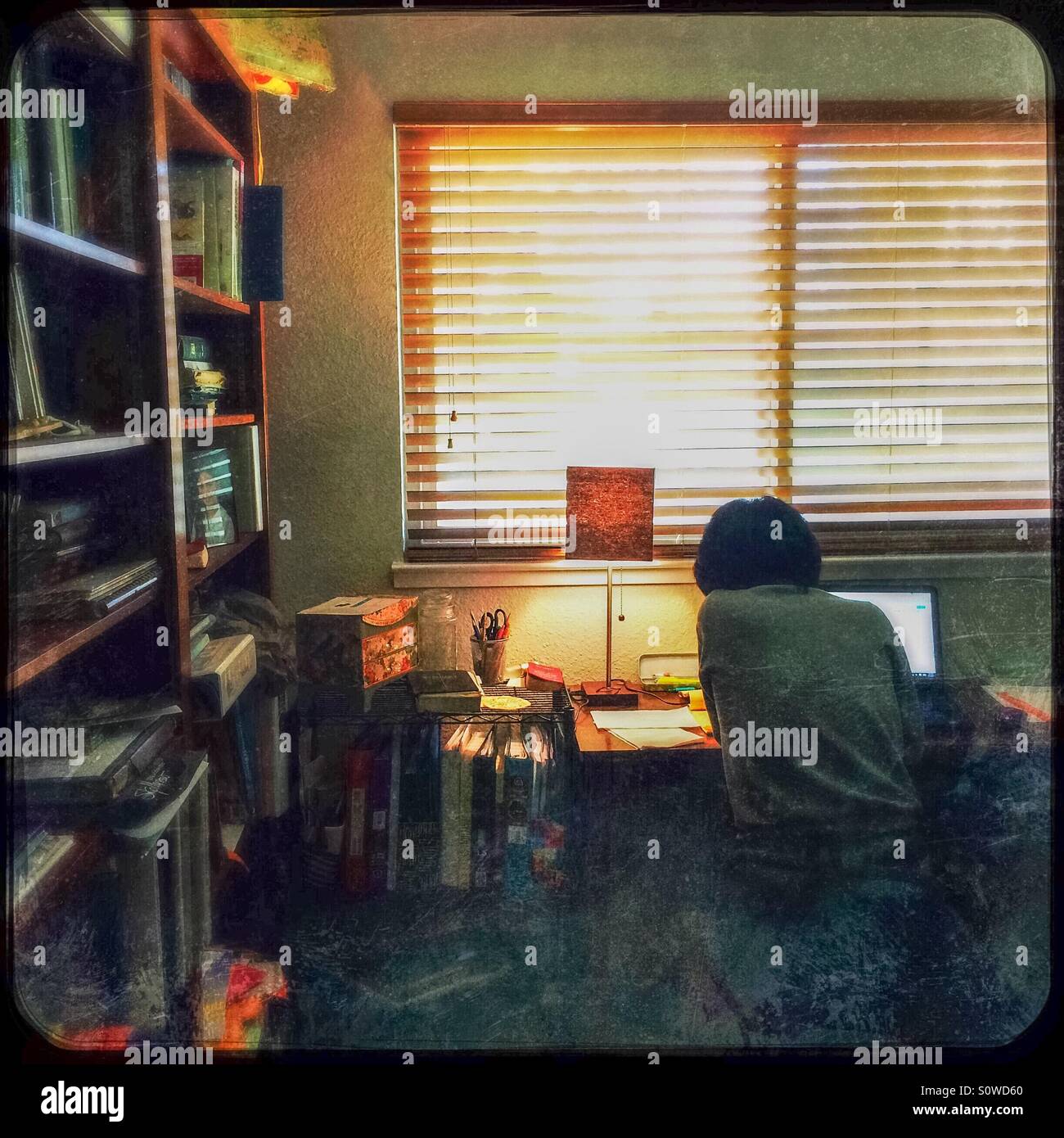 Eine asiatische Frau arbeitet von zu Hause in ihrem Büro. - Smartphone-aufgenommenes Stockfoto