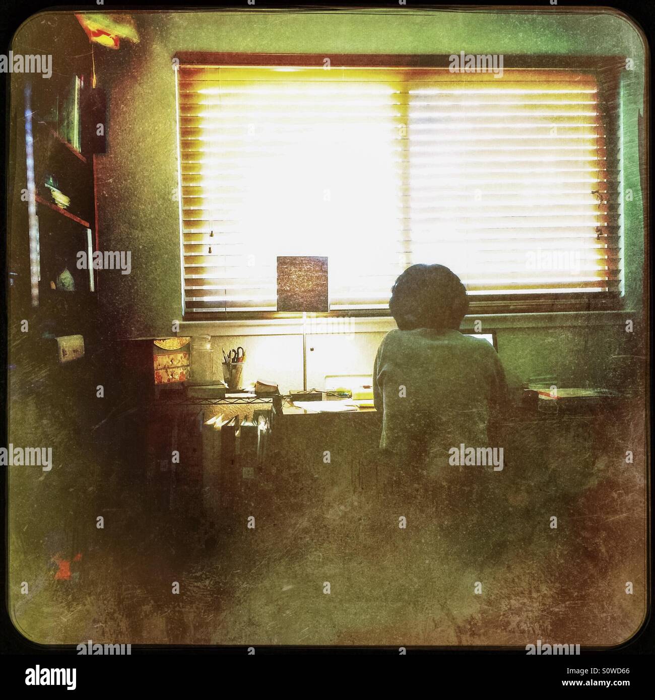 Eine asiatische Frau arbeitet von zu Hause in ihrem Büro. - Smartphone-aufgenommenes Stockfoto