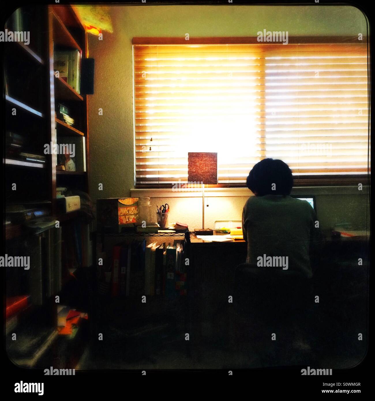 Eine asiatische Frau arbeitet von zu Hause in ihrem Büro. - Smartphone-aufgenommenes Stockfoto