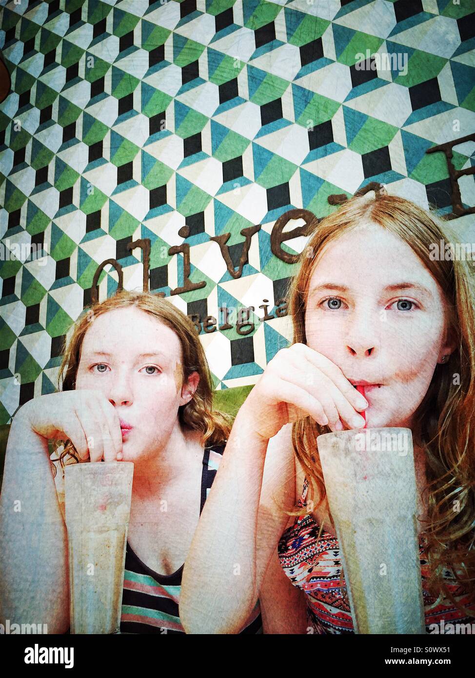 Zwei Mädchen trinken Milchshakes im Café mit geometrischem Muster auf Wände, Vintage-filter Stockfoto