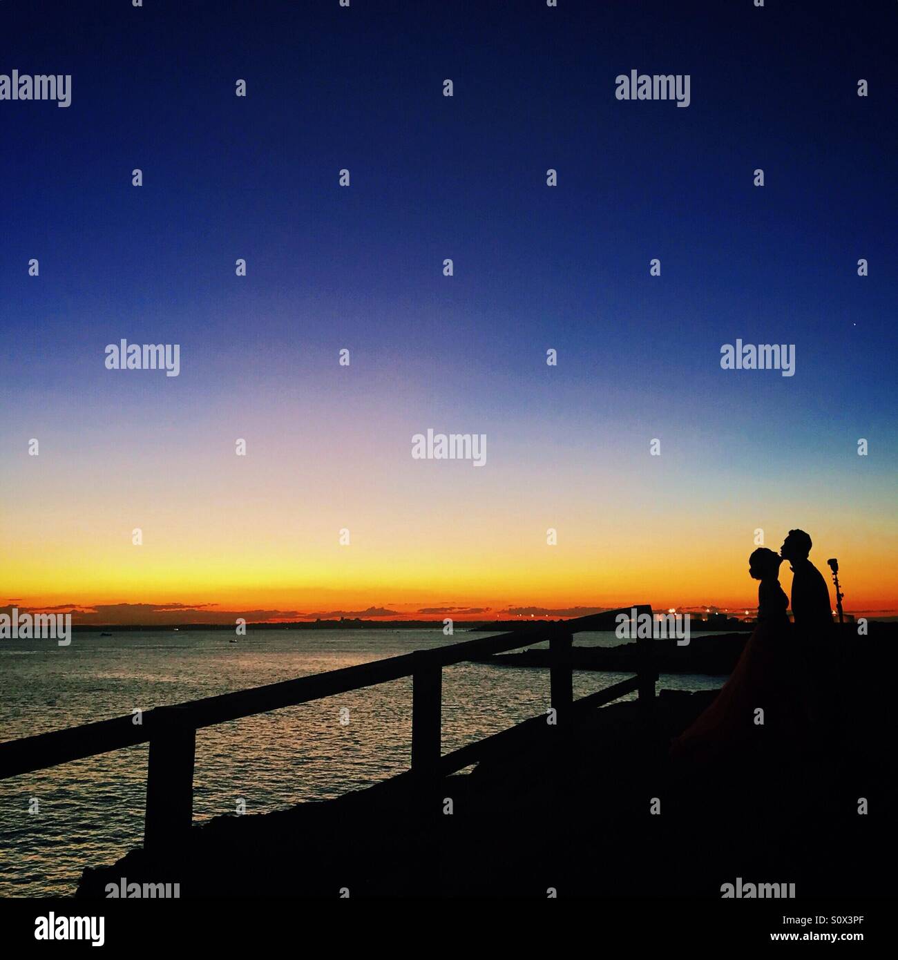 Paar küssen in den wunderschönen Sonnenuntergang Stockfoto