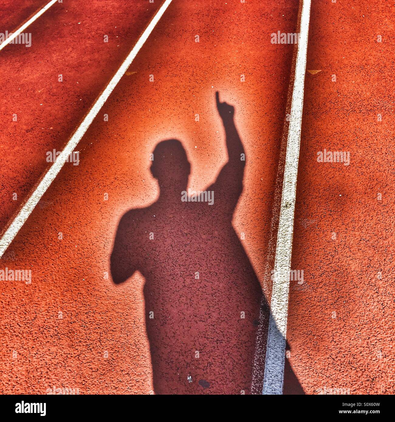 Schatten der Person mit erhobenem Arm halten Sie einen Finger in einer Nummer eins Geste - Smartphone-aufgenommenes Stockfoto