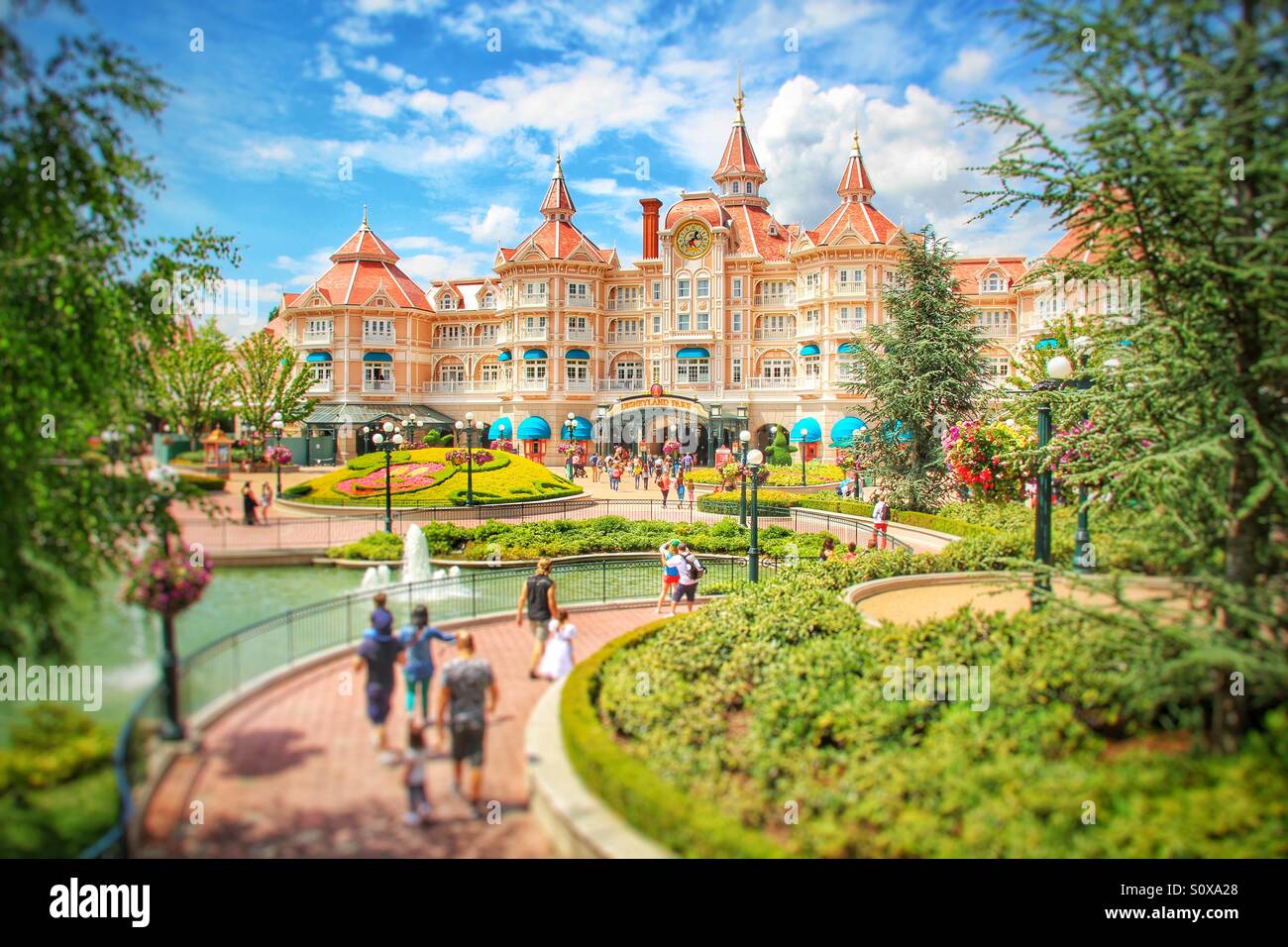 Das Disneyland Hotel in Paris mit Touristen im Vordergrund unter einen wunderschönen blauen Himmel. Stockfoto