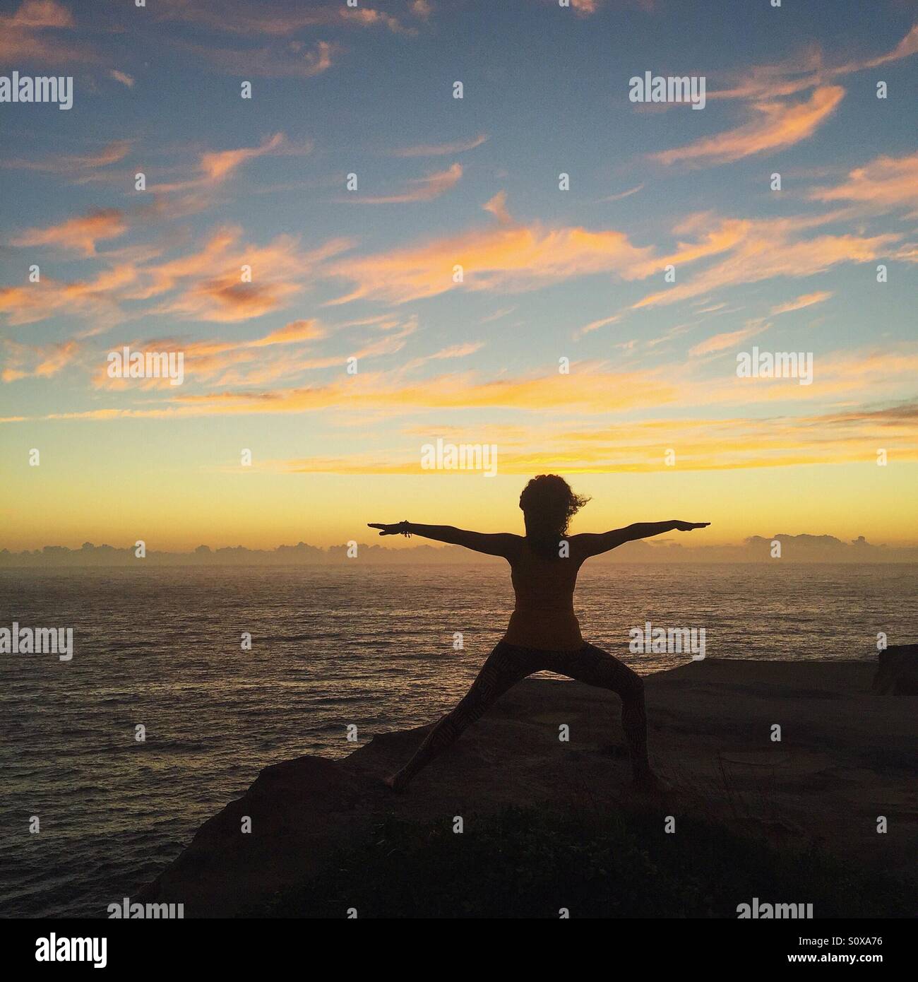 Frau beim Yoga auf der Klippe Stockfoto