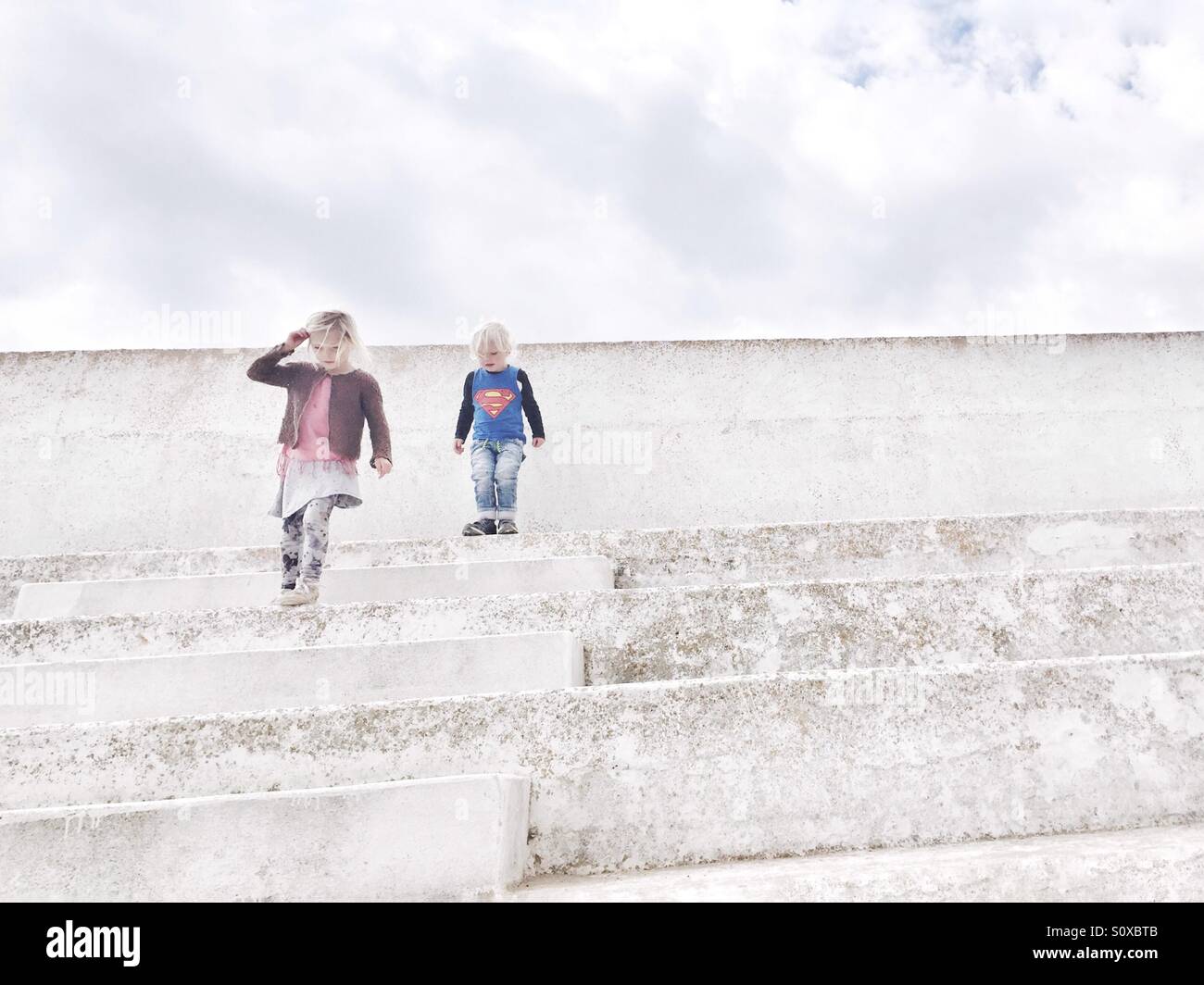 Kinder zu Fuß weiße Treppe hinunter Stockfoto