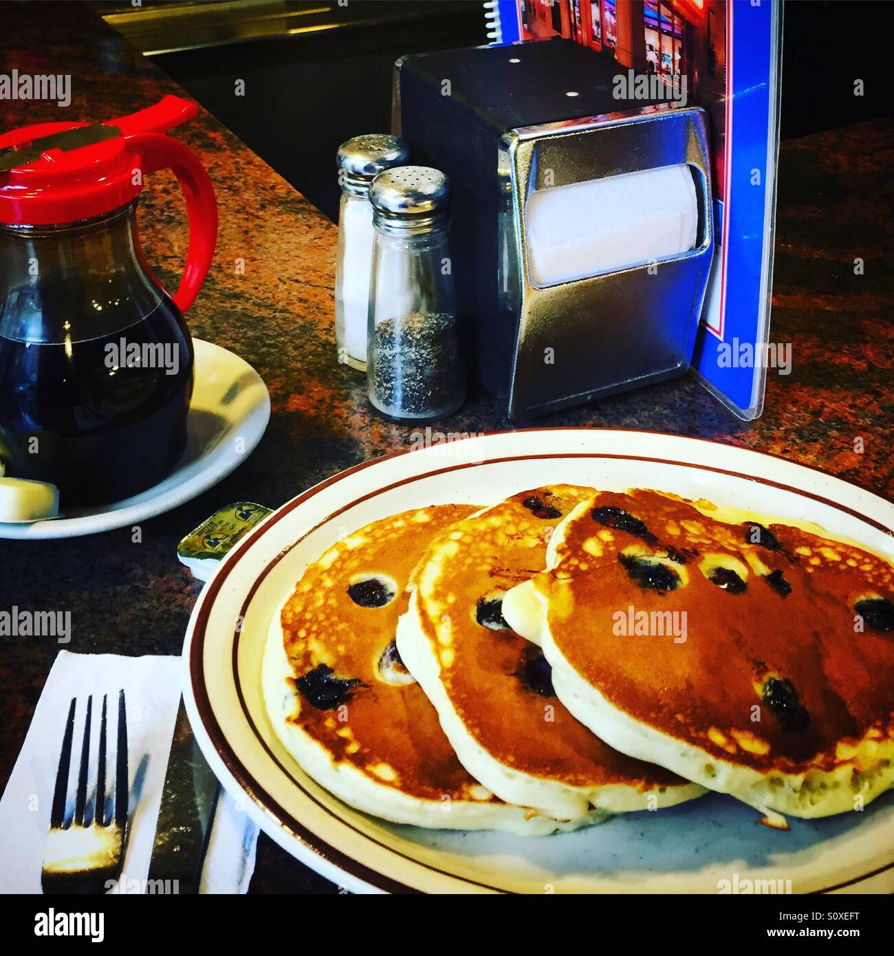 Heidelbeer-Pfannkuchen mit Ahornsirup in einem diner Stockfoto