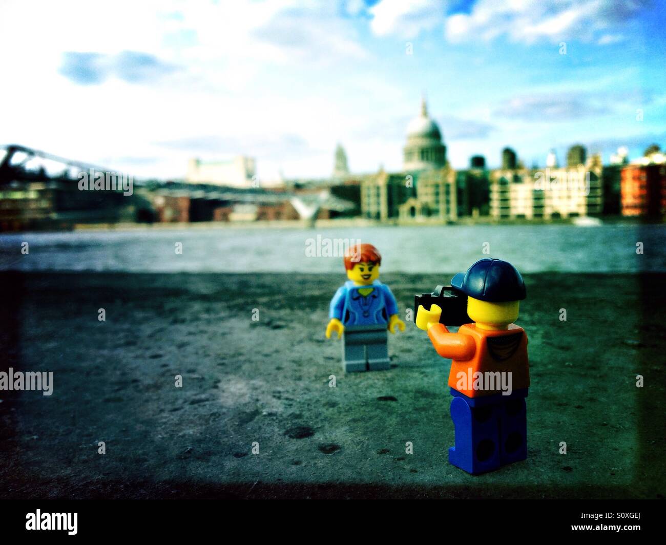 Ein paar Lego Leute fotografieren vor der Millennium Bridge und St. Paul Kathedrale an der Themse in London - Smartphone-aufgenommenes Stockfoto