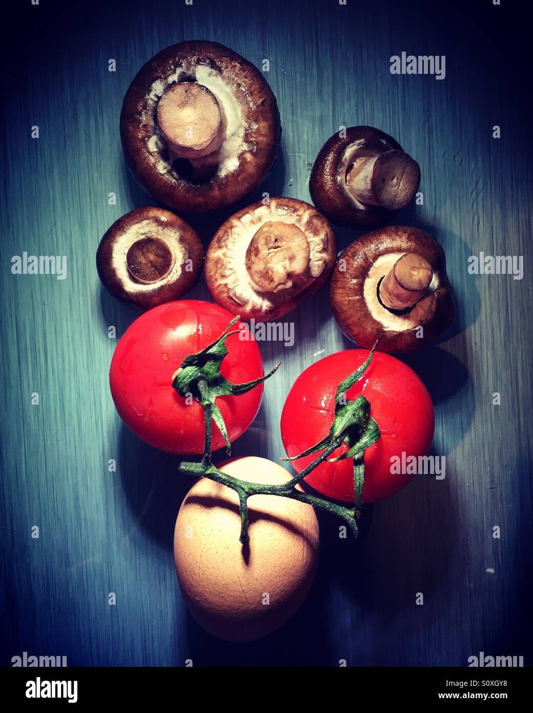 Pilze, Tomaten und ein Ei. Zutaten für das Frühstück - Smartphone-aufgenommenes Stockfoto