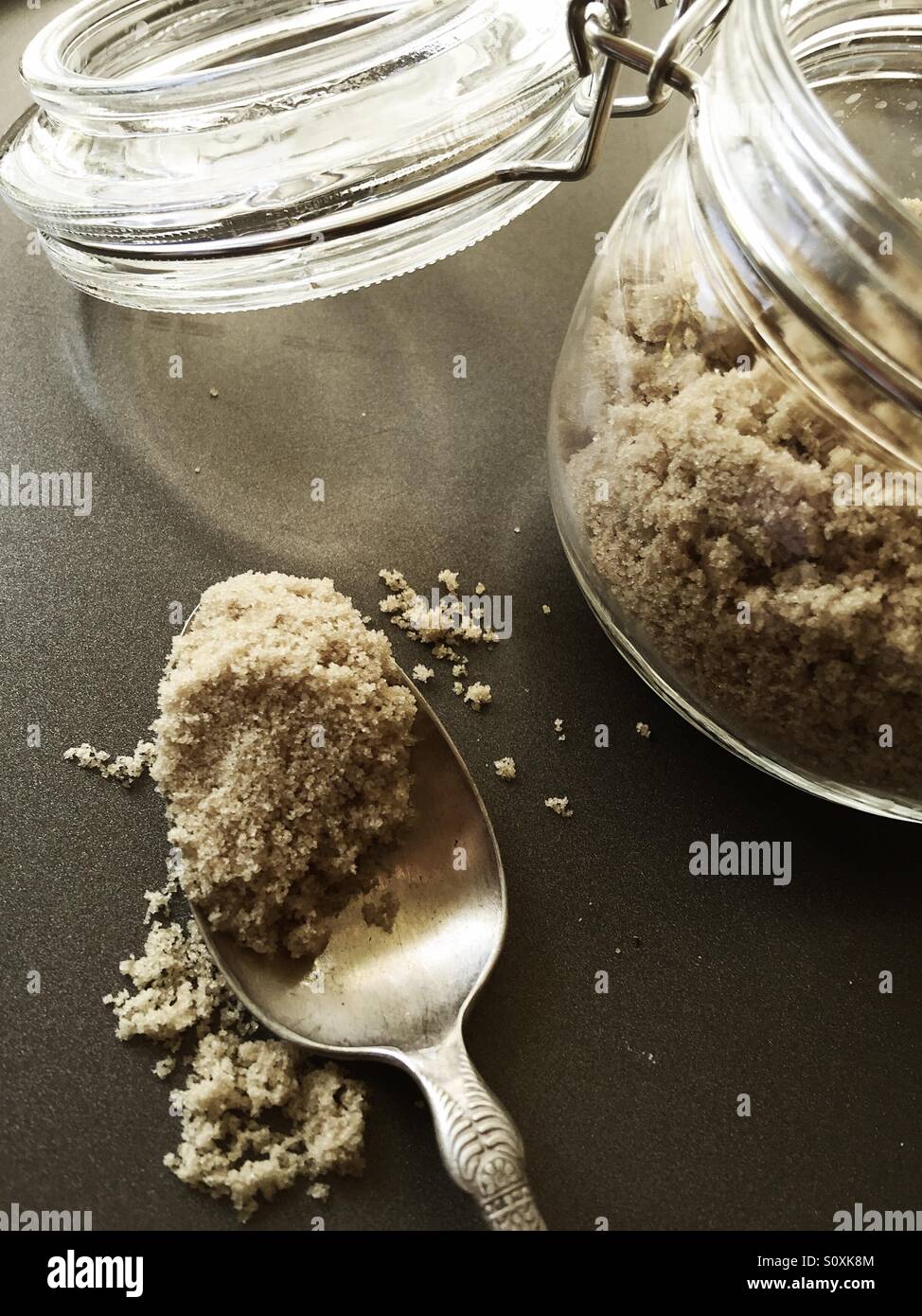 Esslöffel brauner Zucker mit Glas - Smartphone-aufgenommenes Stockfoto