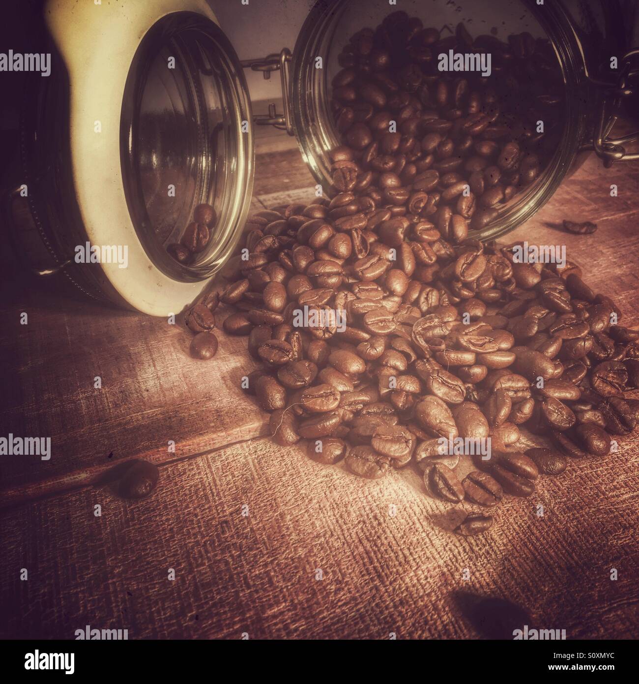 Frischer gerösteter Arabica-Kaffeebohnen Spick von Kilner Typ Weckglas auf ein natürliches Holz verschalt Oberfläche. Stockfoto