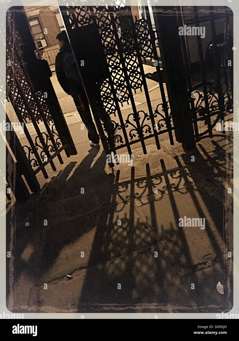 Mann zu Fuß durch schmiedeeiserne Tore beim Sniffen Gericht, Murray Hill, NYC. - Smartphone-aufgenommenes Stockfoto