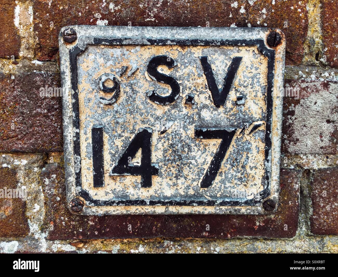 Alten Hydranten S.V Wasserzeichen auf Ziegelmauer Stockfoto