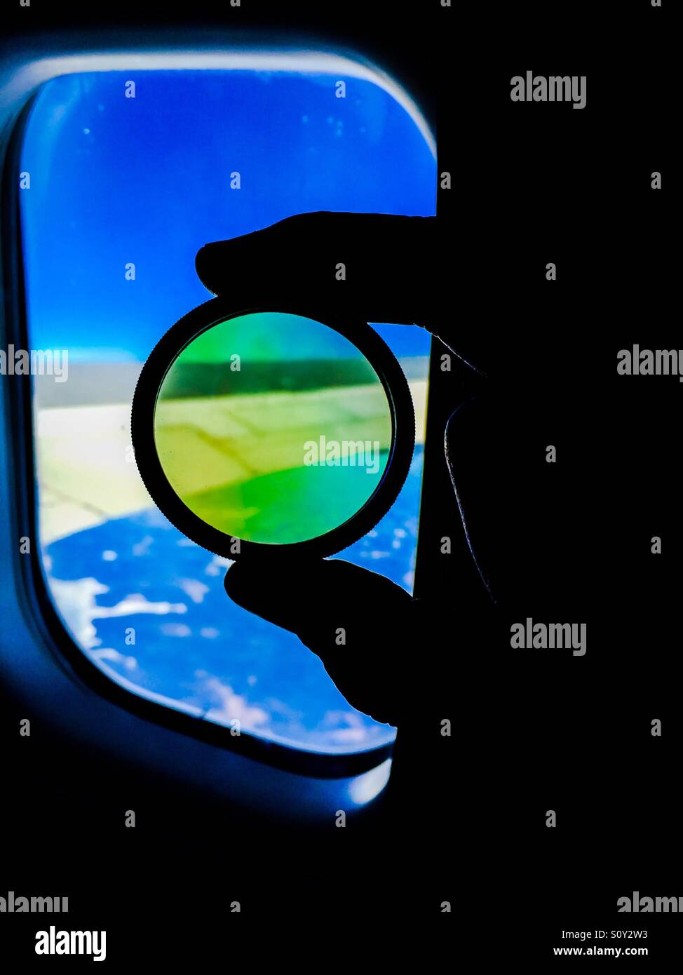 Fenster mit Ansicht. Flug. An Bord. Ein Flügel. Wolken. Blauer Himmel. Ein Filter. Rund. Kopierbereich. Status geändert. Ansicht. Durchschauen. - Smartphone-aufgenommenes Stockfoto