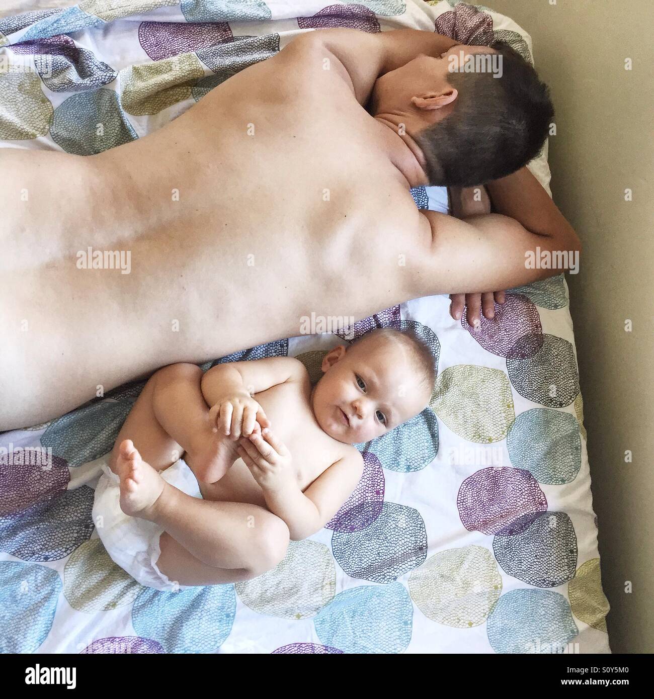 Ein Nickerchen mit seinem Baby Sohn Vater Stockfoto