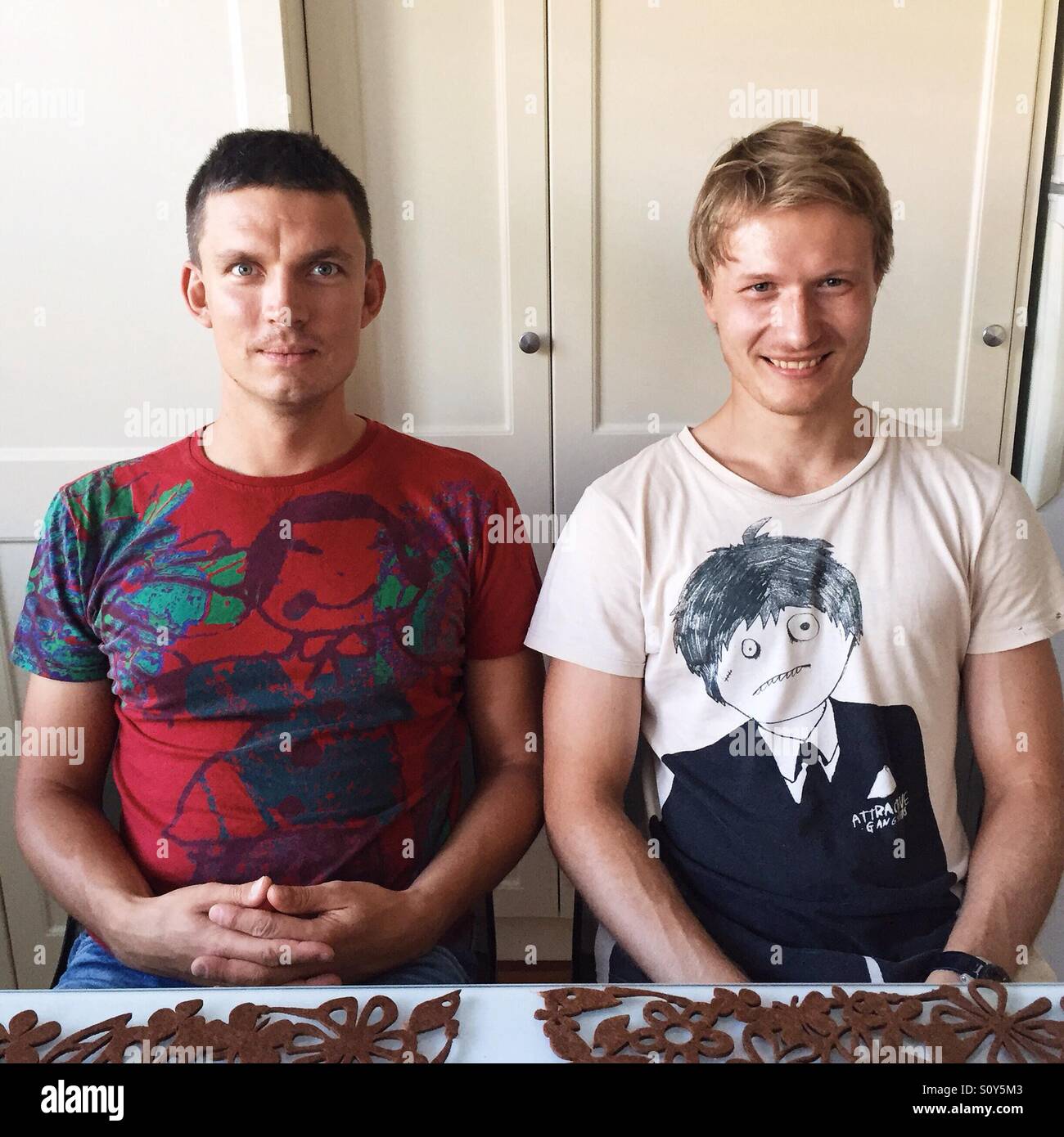 Zwei männliche Personen an einem Tisch sitzen Stockfoto