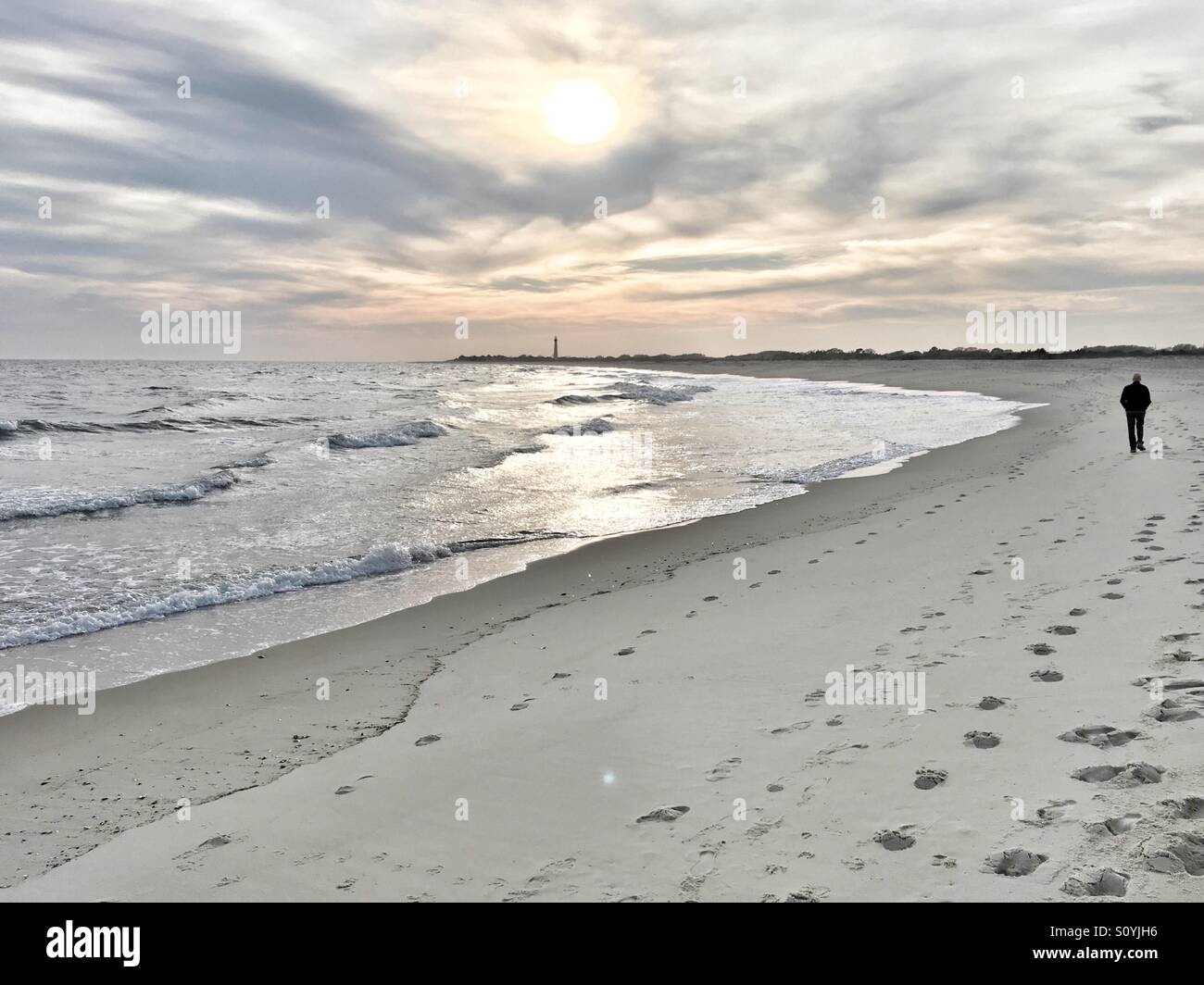 Mann in der Strand zu Fuß in Richtung Leuchtturm, Cape May, New Jersey, USA Stockfoto