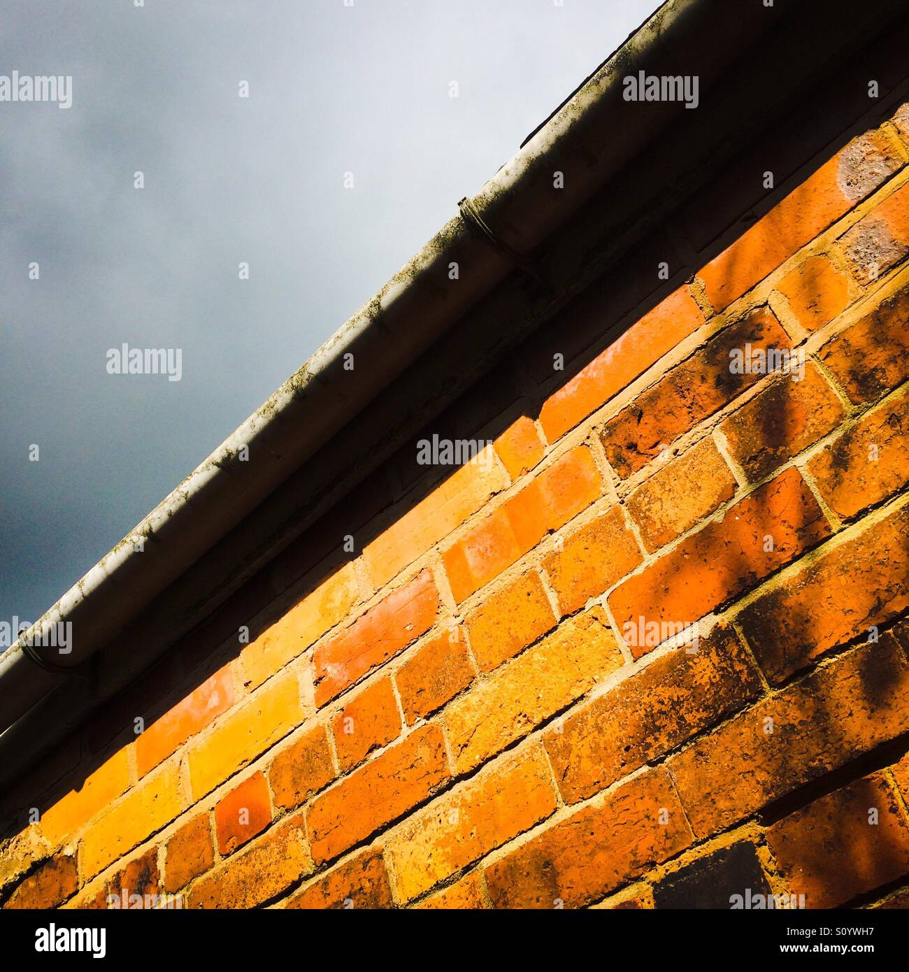 Ziegelmauer und Dachlinie des Hauses mit sky Stockfoto