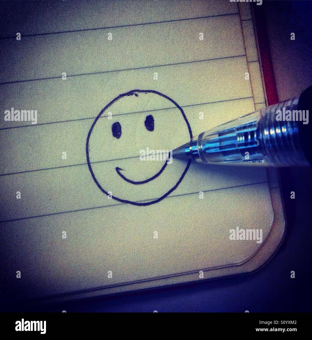 Einen Smiley zeichnen in der Ecke ein Booknote mit einem Bleistift Stockfoto