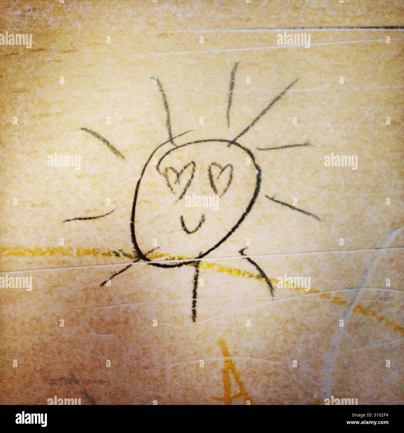 Lächelnde Sonne Bleistiftzeichnung auf einem Schultisch Stockfoto