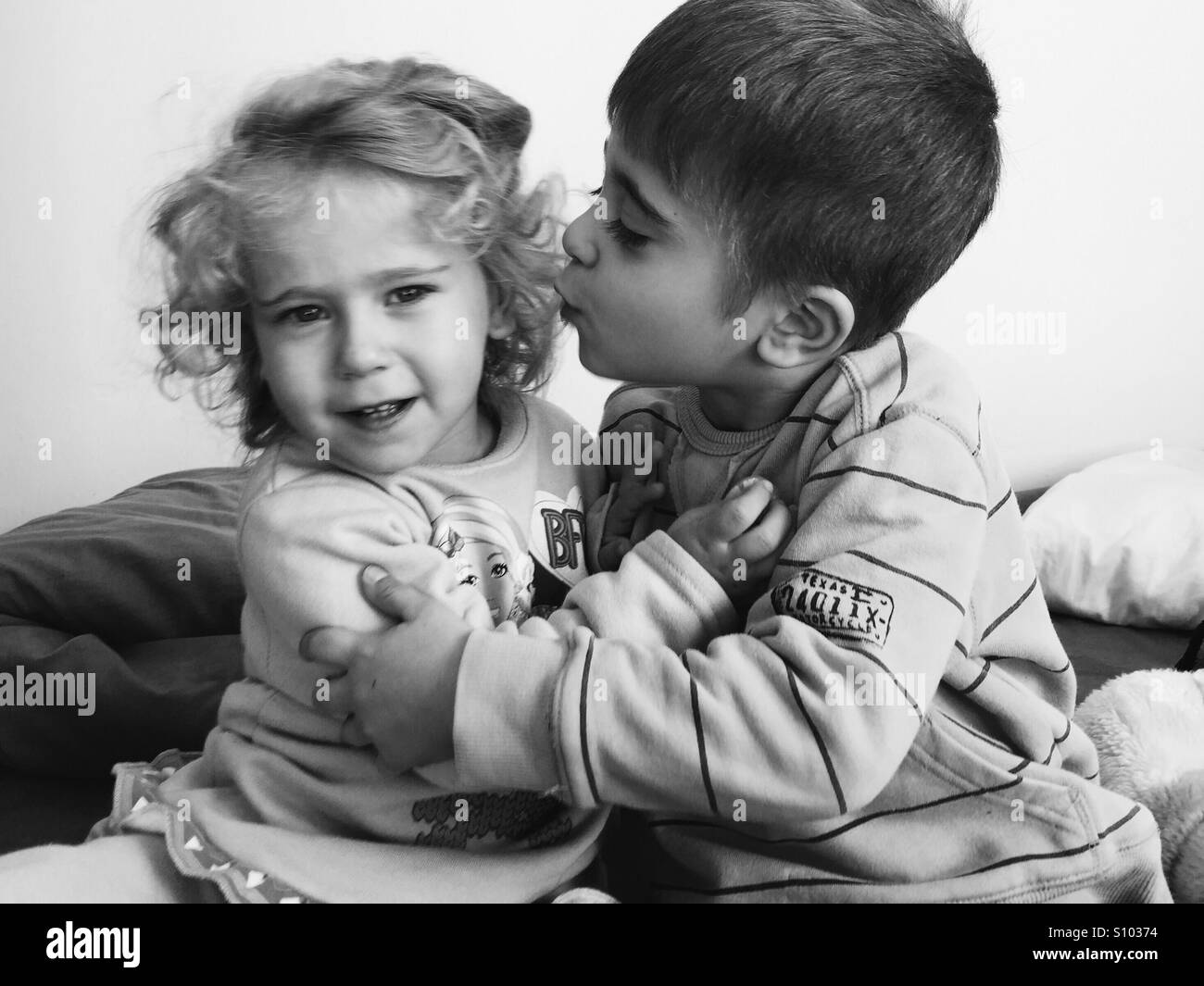 Bruder und Schwester Umarmungen und Küsse. Schwarz / weiß Stockfoto