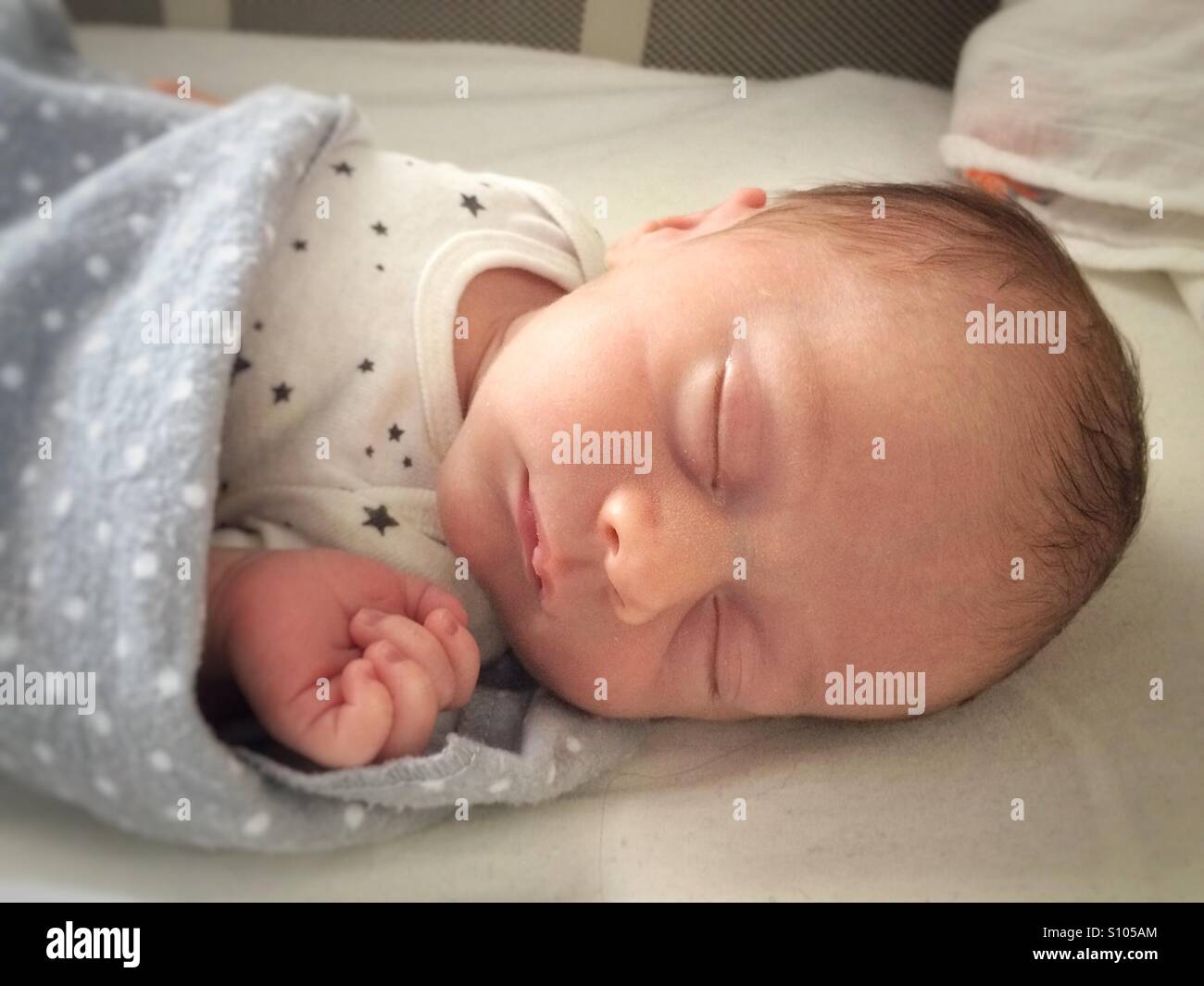 Ein Neugeborenes schläft in einer Krippe. Stockfoto
