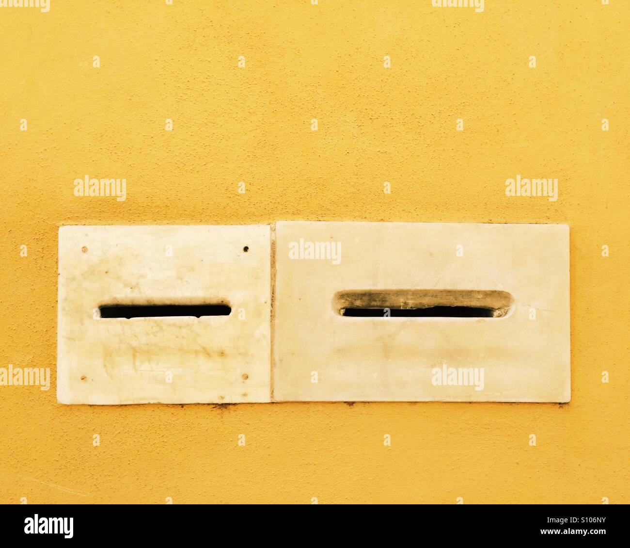 Briefkästen auf eine gelbe Wand in Arezzo, Toskana. Stockfoto