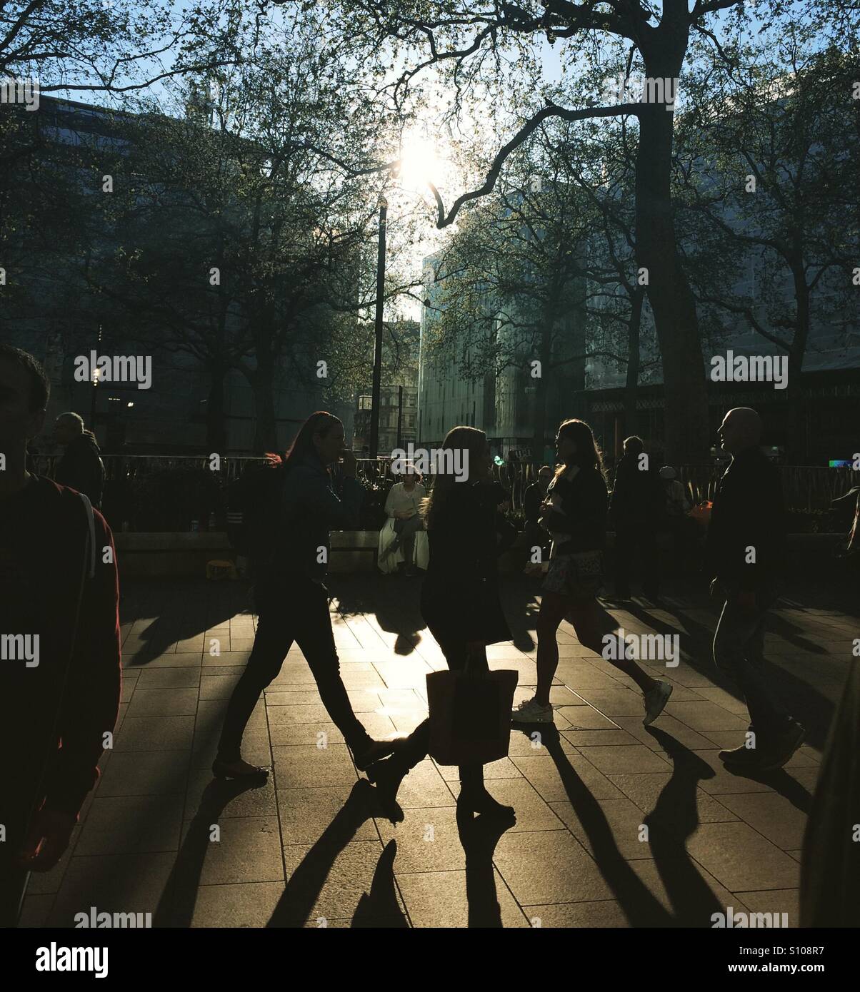 Silhouetten von Käufern in einer belebten Straße bei schwachem Licht Stockfoto