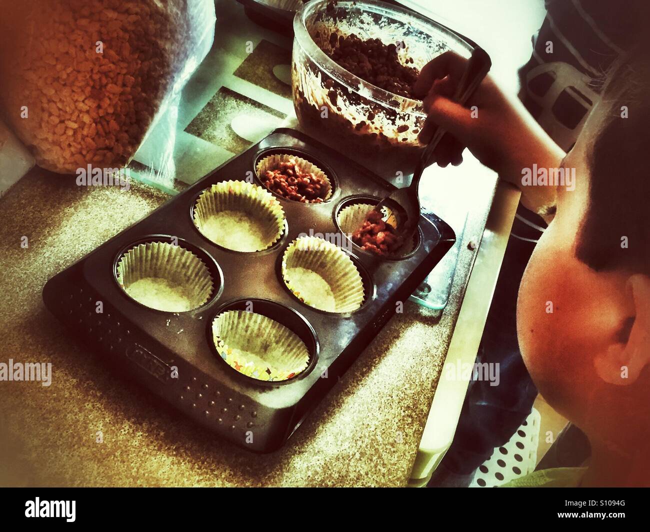 Ein Junge, die Herstellung von Schokolade Reis knuspriger. - Smartphone-aufgenommenes Stockfoto