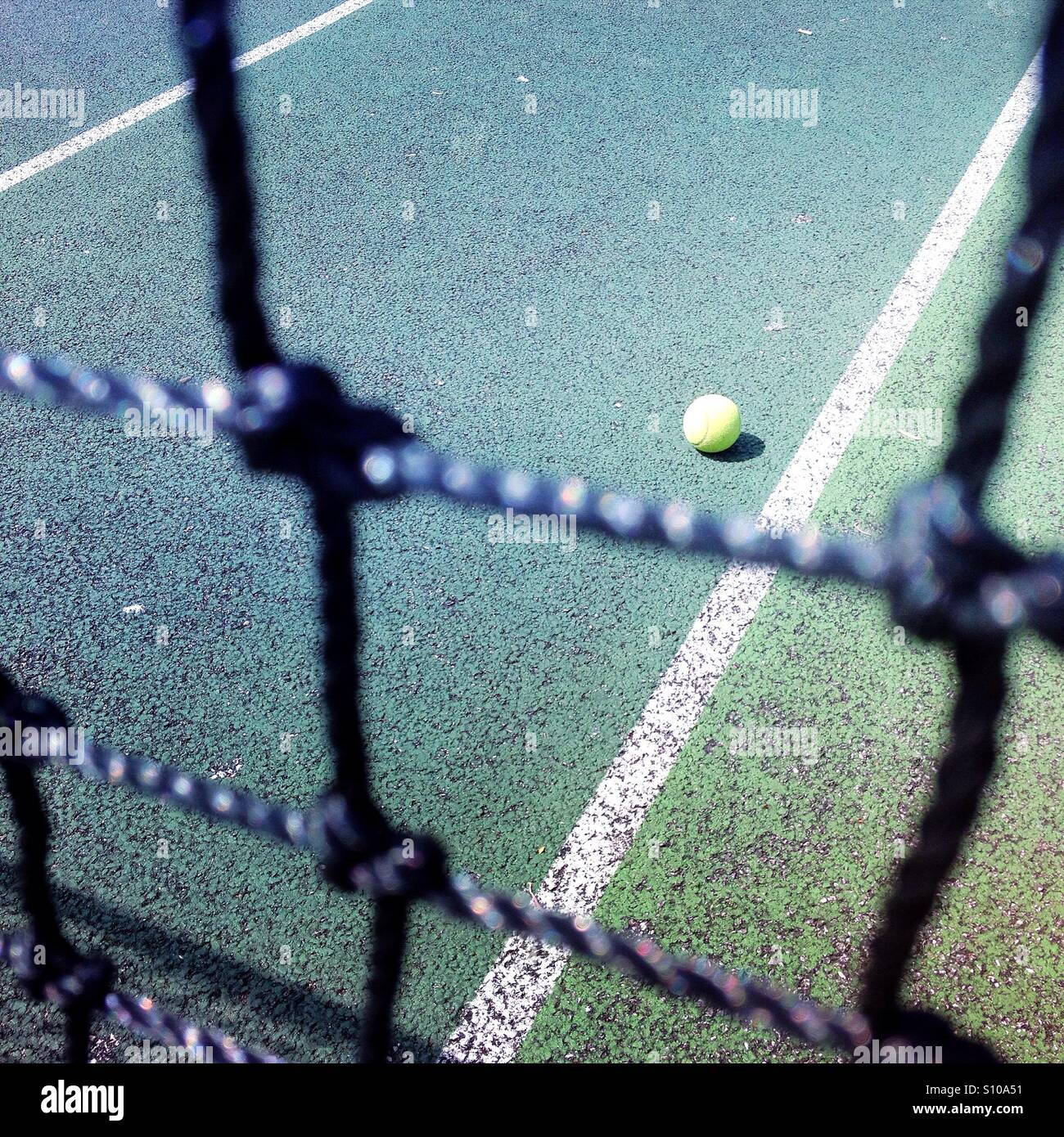 Ansicht eines Tennisplatzes durch das Netz - Smartphone-aufgenommenes Stockfoto
