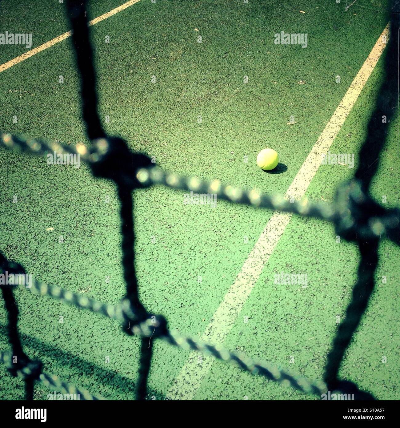 Blick auf einen Tennisball durch einen Tennisplatz Netto - Smartphone-aufgenommenes Stockfoto
