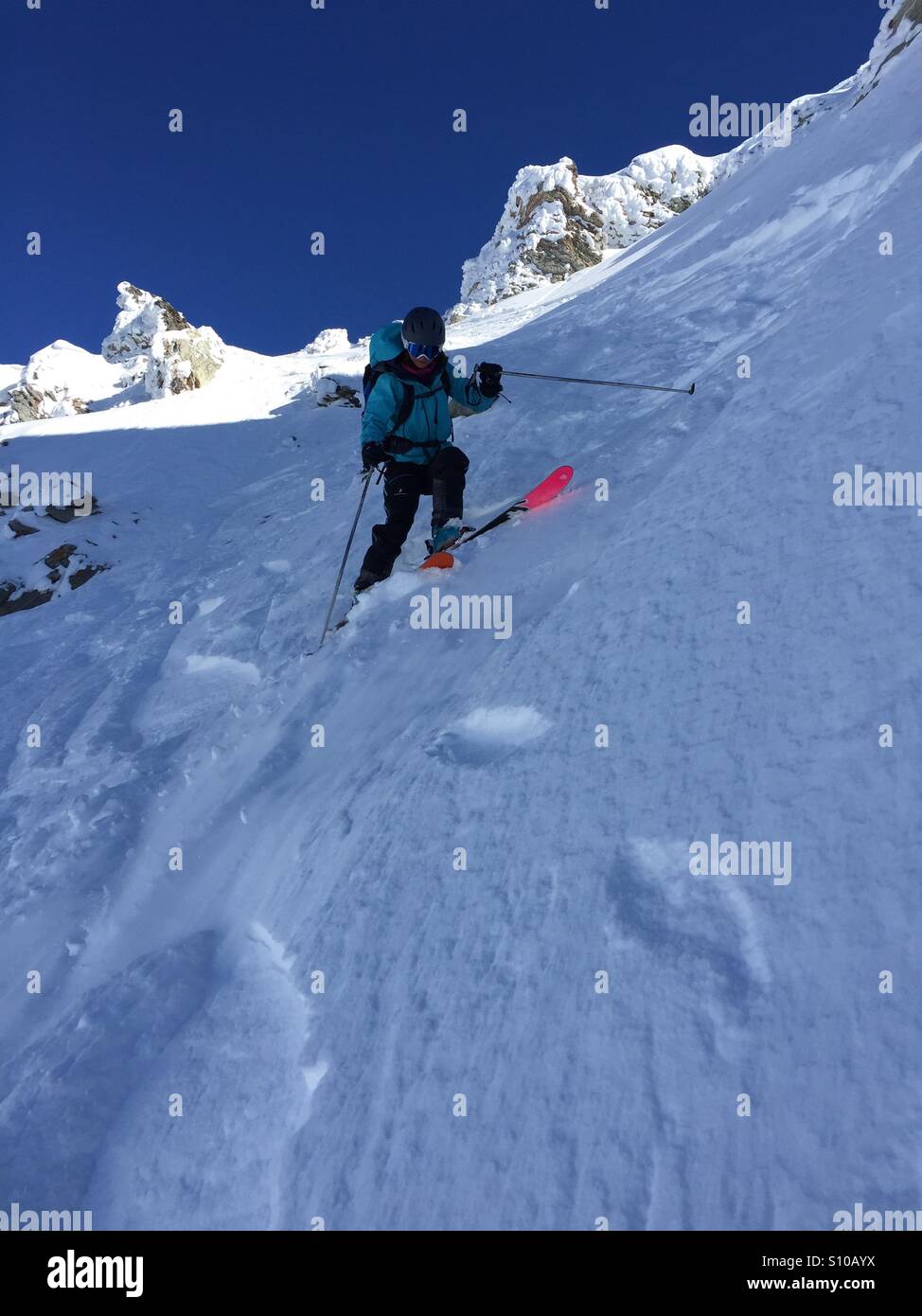 Junge Frau Skifahren abseits der Pisten in der Schweiz. Stockfoto