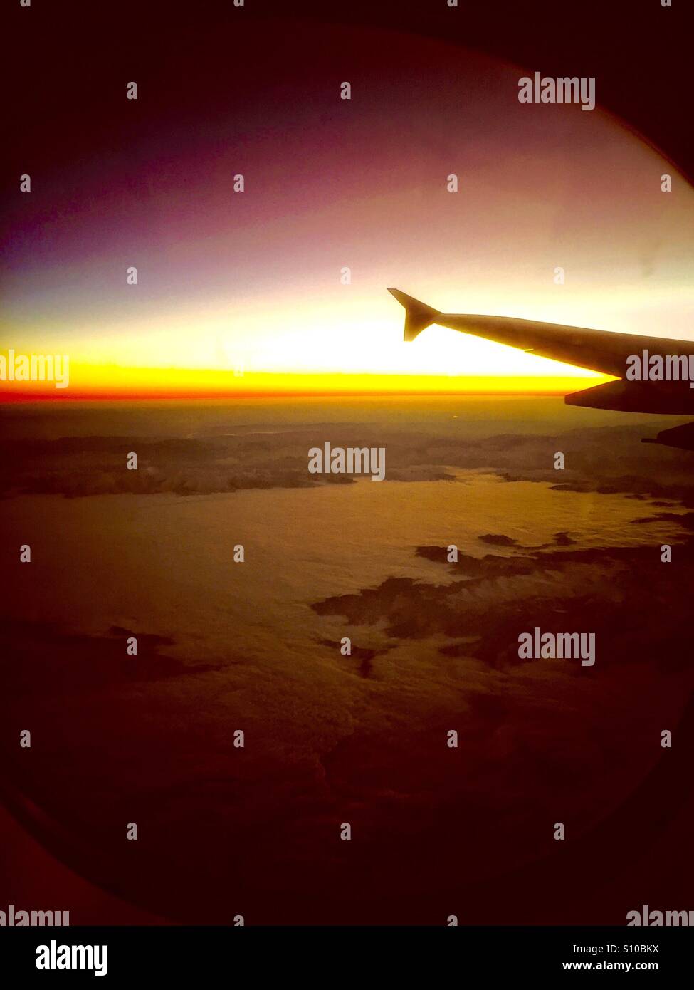 Sonnenaufgang am Horizont gesehen aus dem Flugzeug Stockfoto