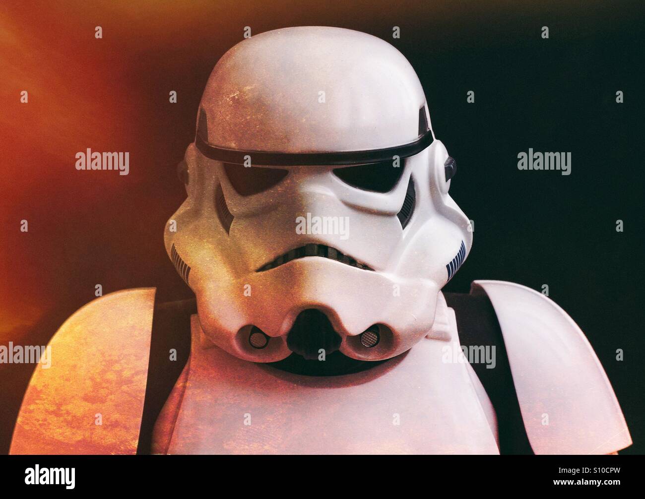 Eine Star Wars Stormtrooper umgeben von Flammen auf schwarzem Hintergrund und direkt in die Kamera schaut. - Smartphone-aufgenommenes Stockfoto