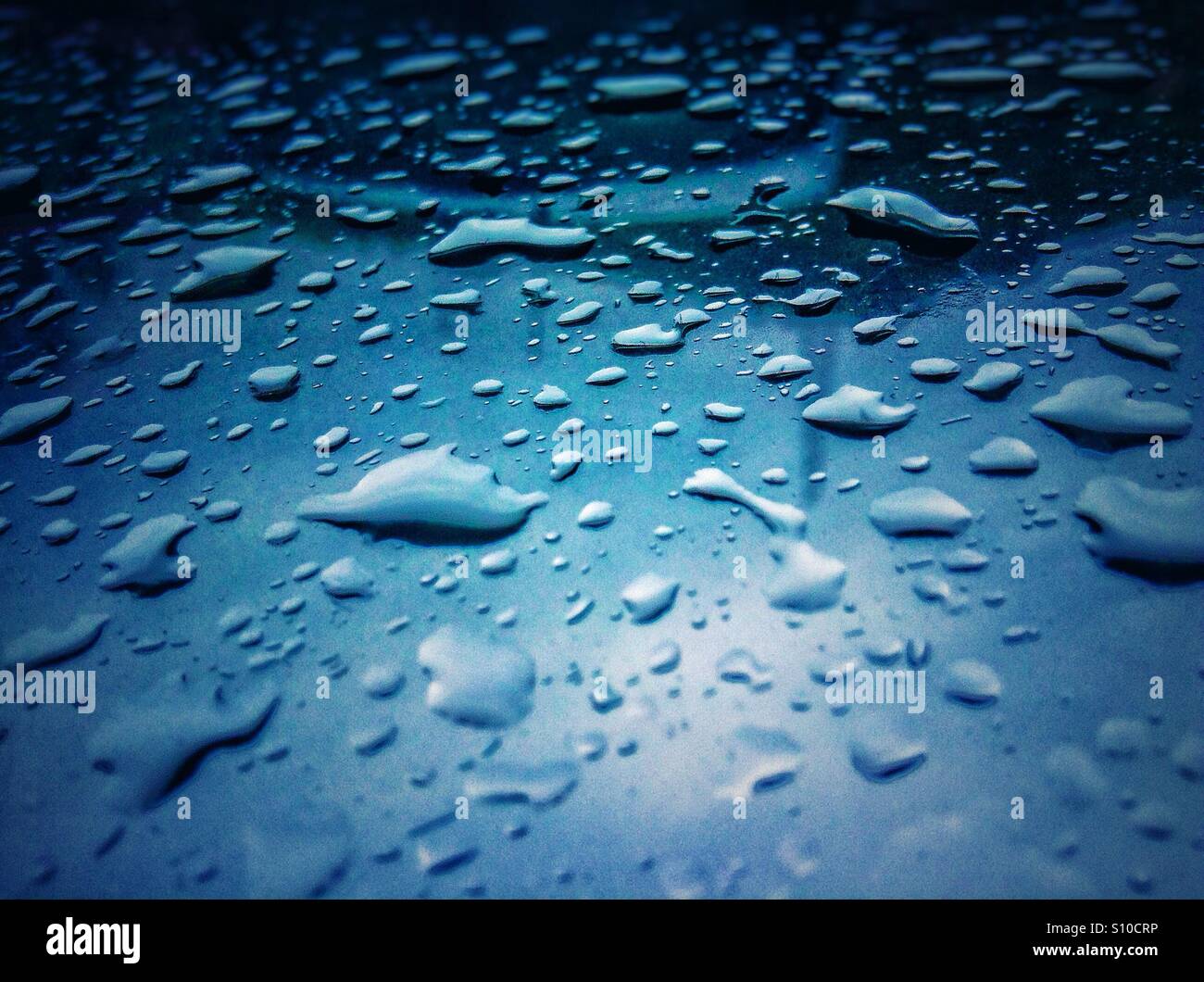 Tropfen, wenn Regenwasser auf ein Glas Stockfoto