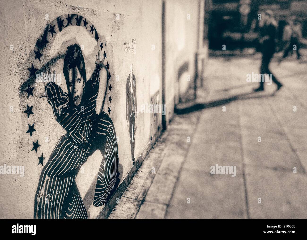 David Bowie-Wandbild. Mann auf dem Handy. Holz grün Einkaufsstadt. London. U.K. Stockfoto