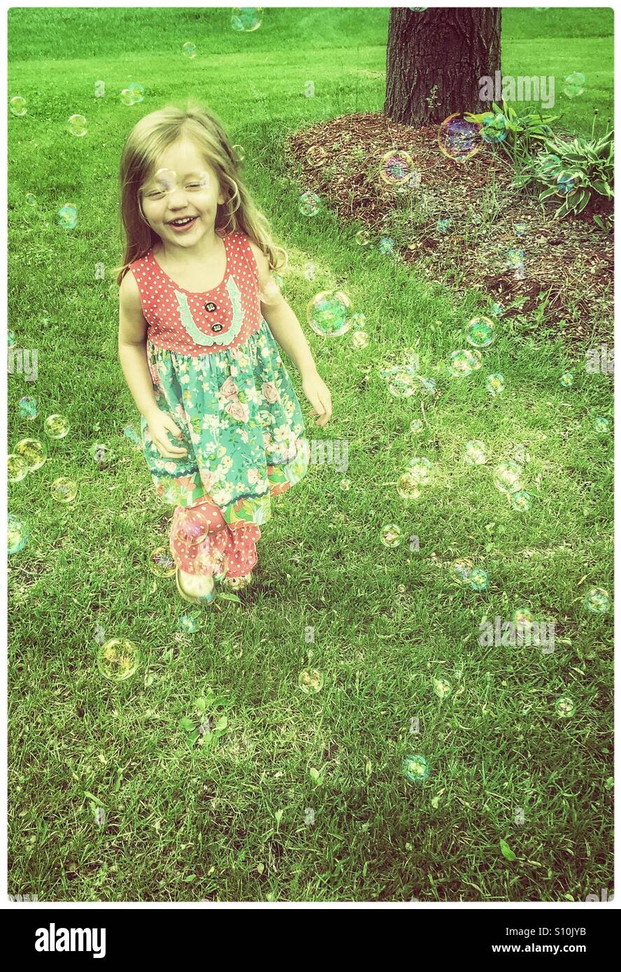 Kleines Mädchen läuft durch Luftblasen Stockfoto