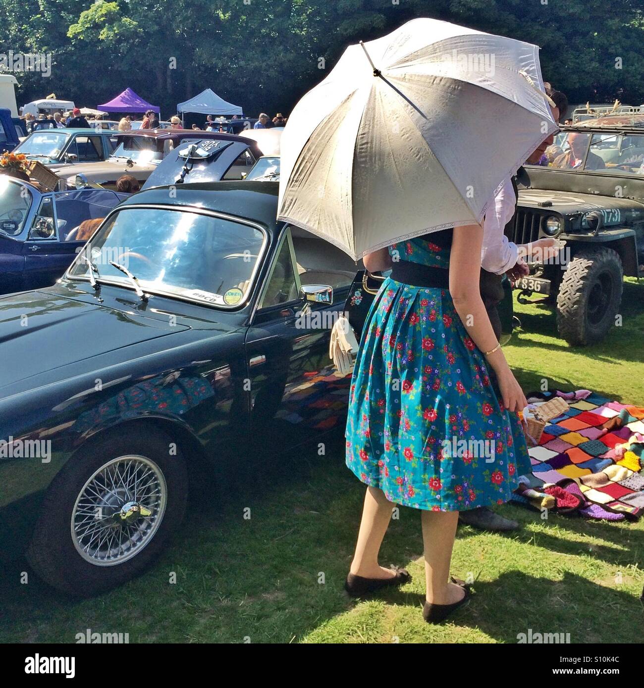 Ein Oldtimer-Besitzer gekleidet in Vintage-Kleidung bei einem Autofestival in England - Smartphone-aufgenommenes Stockfoto