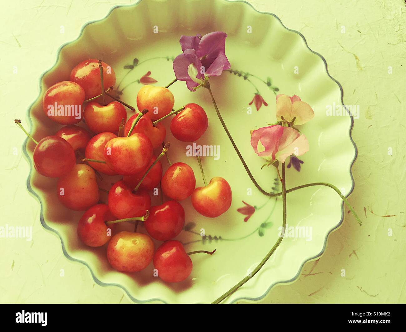 Kirschen und Zuckererbsen auf dekorative Schale - Smartphone-aufgenommenes Stockfoto